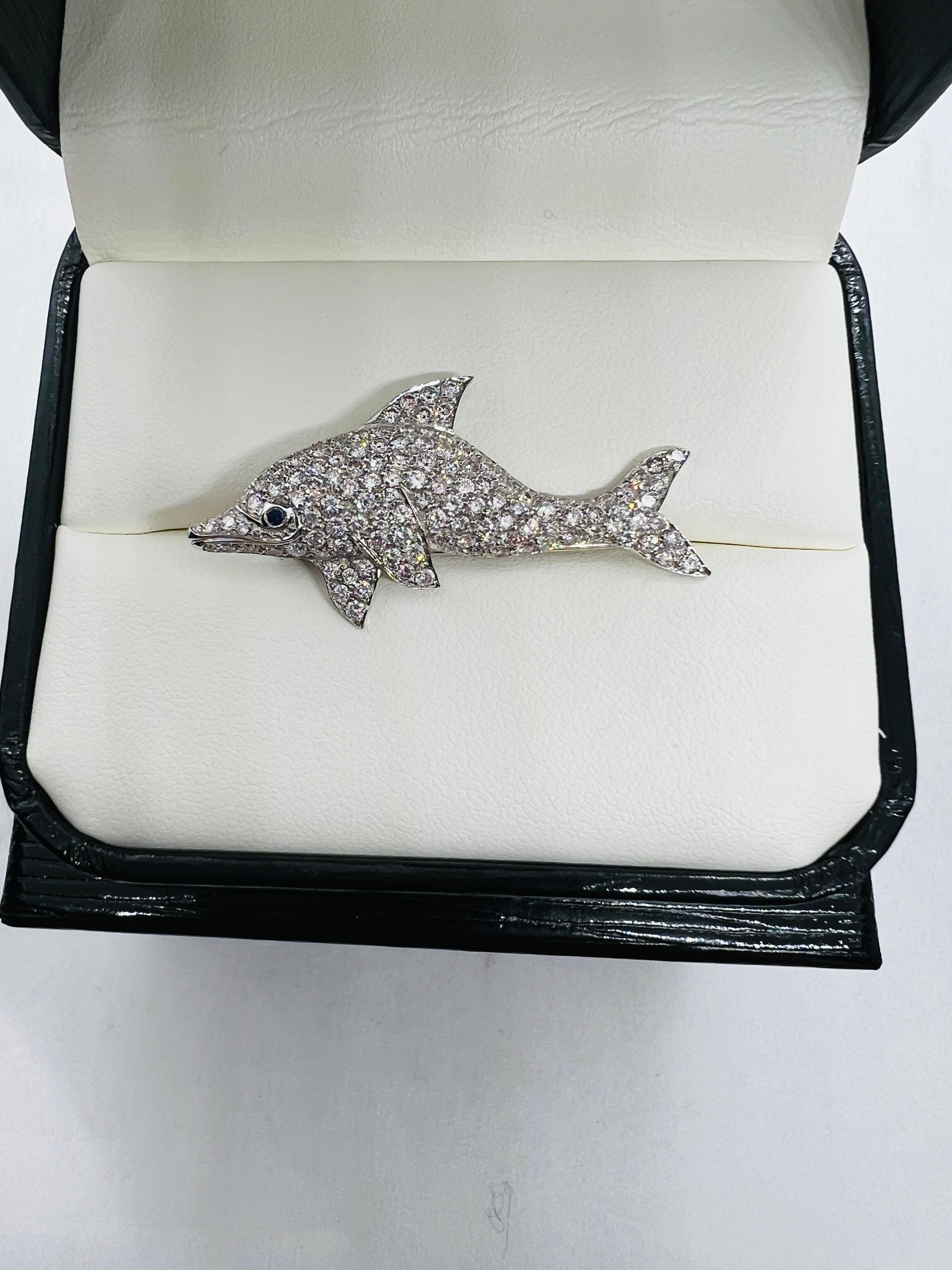 This is a Stunning Dolphin Brooch! Made in Platinum and features two carats of pave set, round , brilliant cut Diamonds. The diamonds are H-I color and Vs clarity. This beauty all features a single Blue Sapphire for the eye. The piece measures 1.5