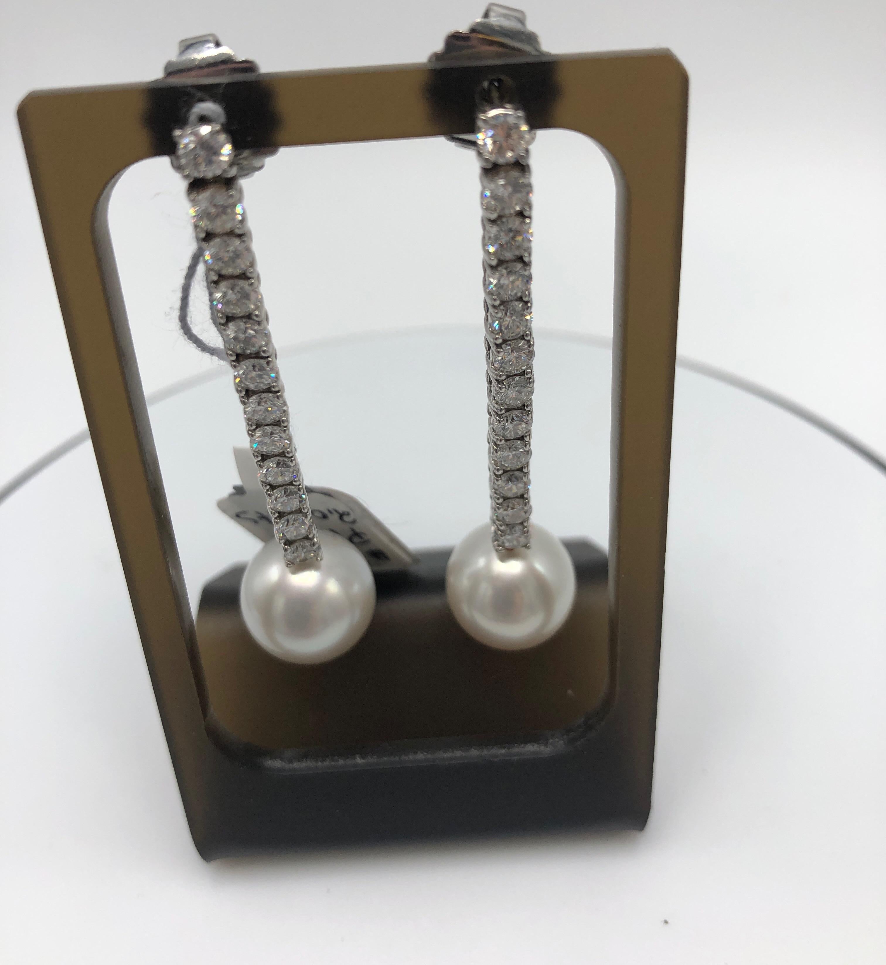 Pair of Platinum Diamond Earrings.  These amazing earrings feature a line of 12 diamonds, suspending a pearl.  Two inches long.  2CTW