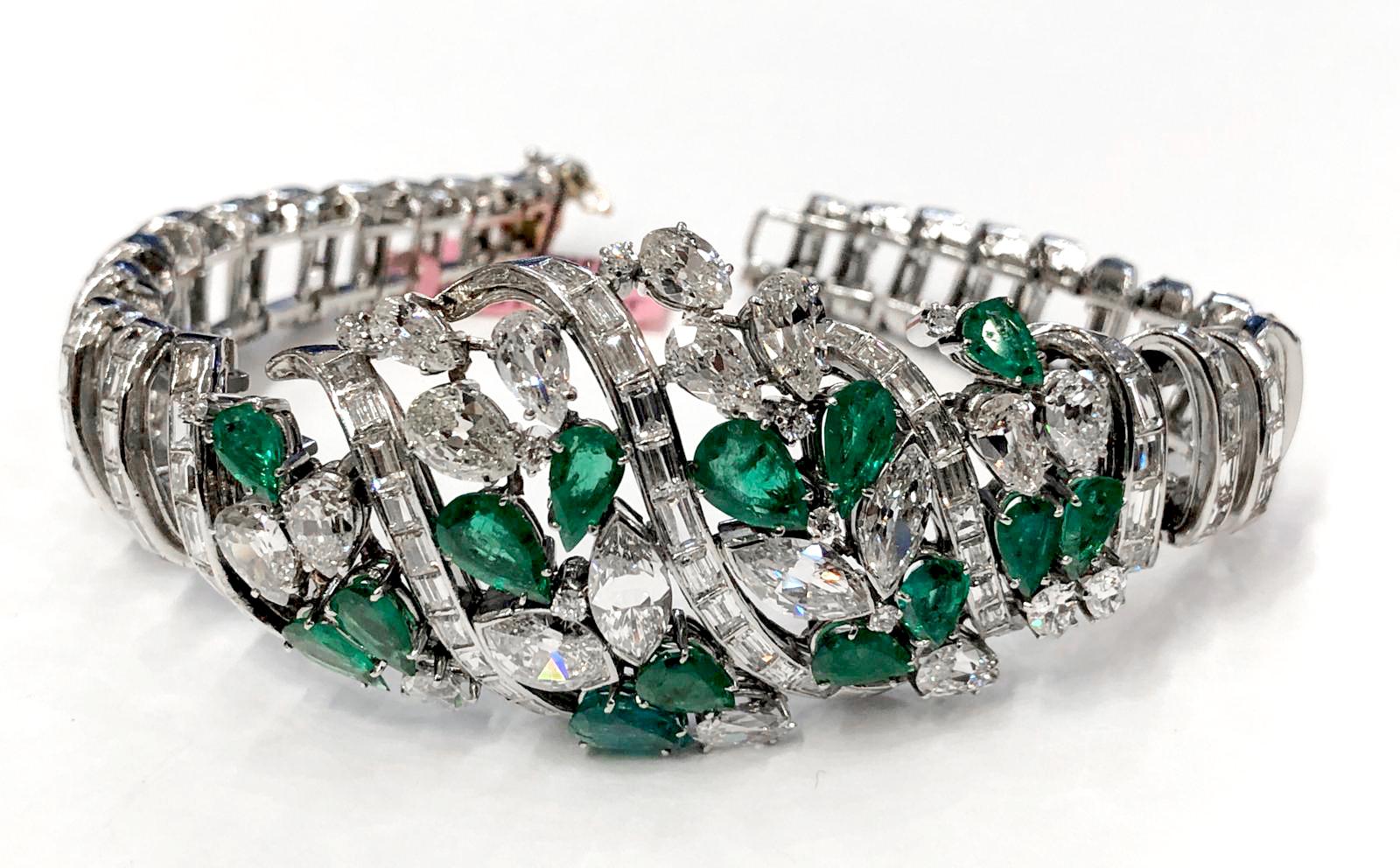 Of openwork design, set with swirling ribbon-like lines of baguette diamonds, the center set with clusters of pear-shaped emeralds, and pear-, marquise-shaped and brilliant-cut diamonds bracelet.
length approx. 180mm.
approx. 18 cts. diamonds