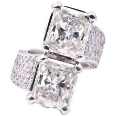 Anello in platino con diamante taglio smeraldo e doppia pietra centrale