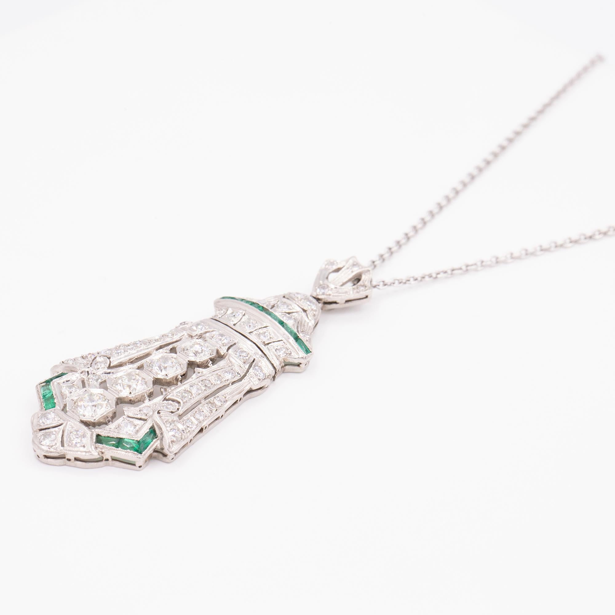 Vintage Diamond & Emerald shield shaped pendant. The pendant has 4 round diamonds weighing approximately 1.14 total carat weight with smaller diamonds weighing 1.06 total carat weight. The emeralds weigh approximately .55 carats in total weight.