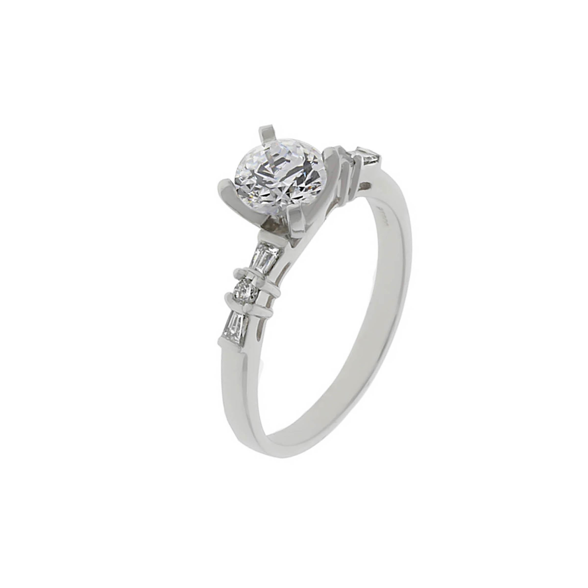 Platinum ring containing one round brilliant cut diamond weighing 1.01 carats, G color, SI2 clarity. The mounting contains 4 baguettes and 2 round diamonds weighing combined 0.16 carat.
The center diamond is GIA certified.
Ring can be sized.