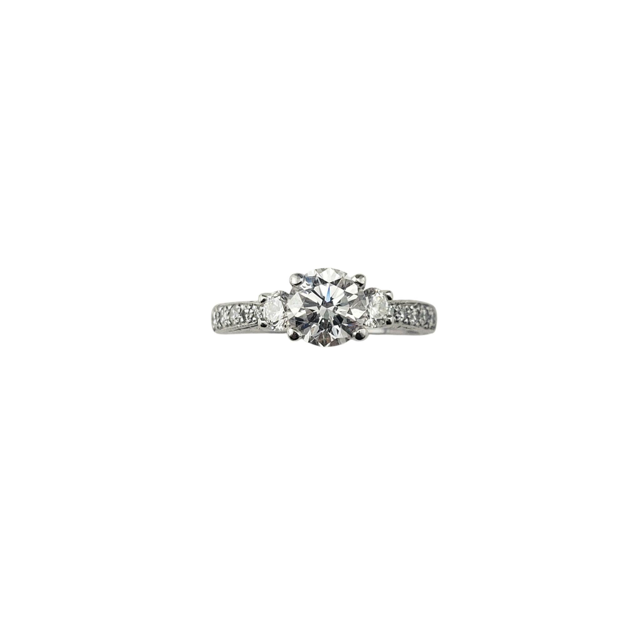 Bague de fiançailles en platine diamant taille 8 JAGi Certified-

Cette élégante bague en platine est ornée d'un superbe diamant rond de taille brillant (environ 1,14 ct.) en son centre. La pierre centrale est flanquée de deux diamants ronds de