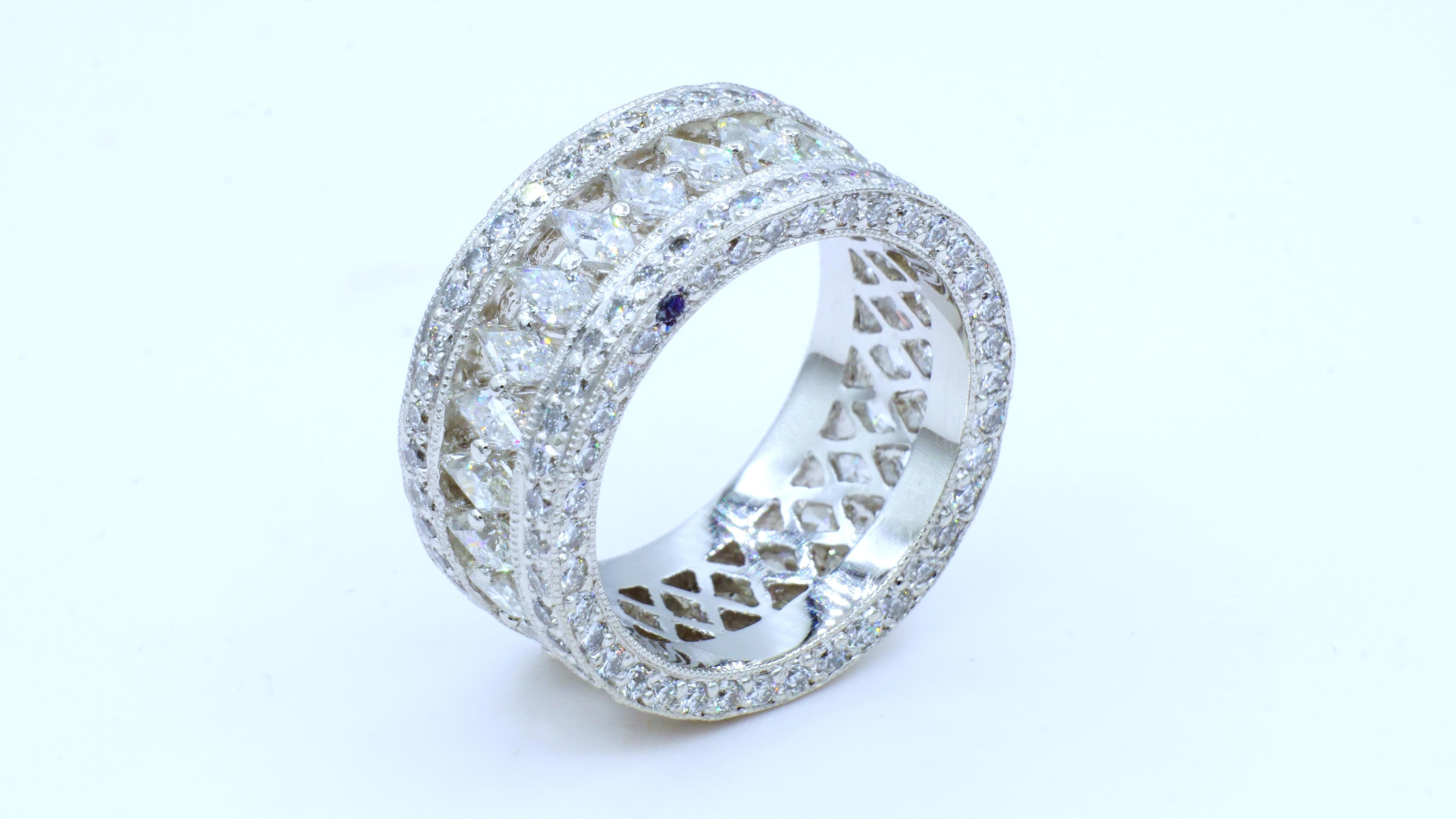 True one-of-a-kind custom platinum eternity ring showcasing a center row of  25 channel/prong set custom-cut diamonds of 3.00cttw. Accenting the center row of diamonds are two rows of 162 round brilliant diamonds that are 1.80cttw.  On the side