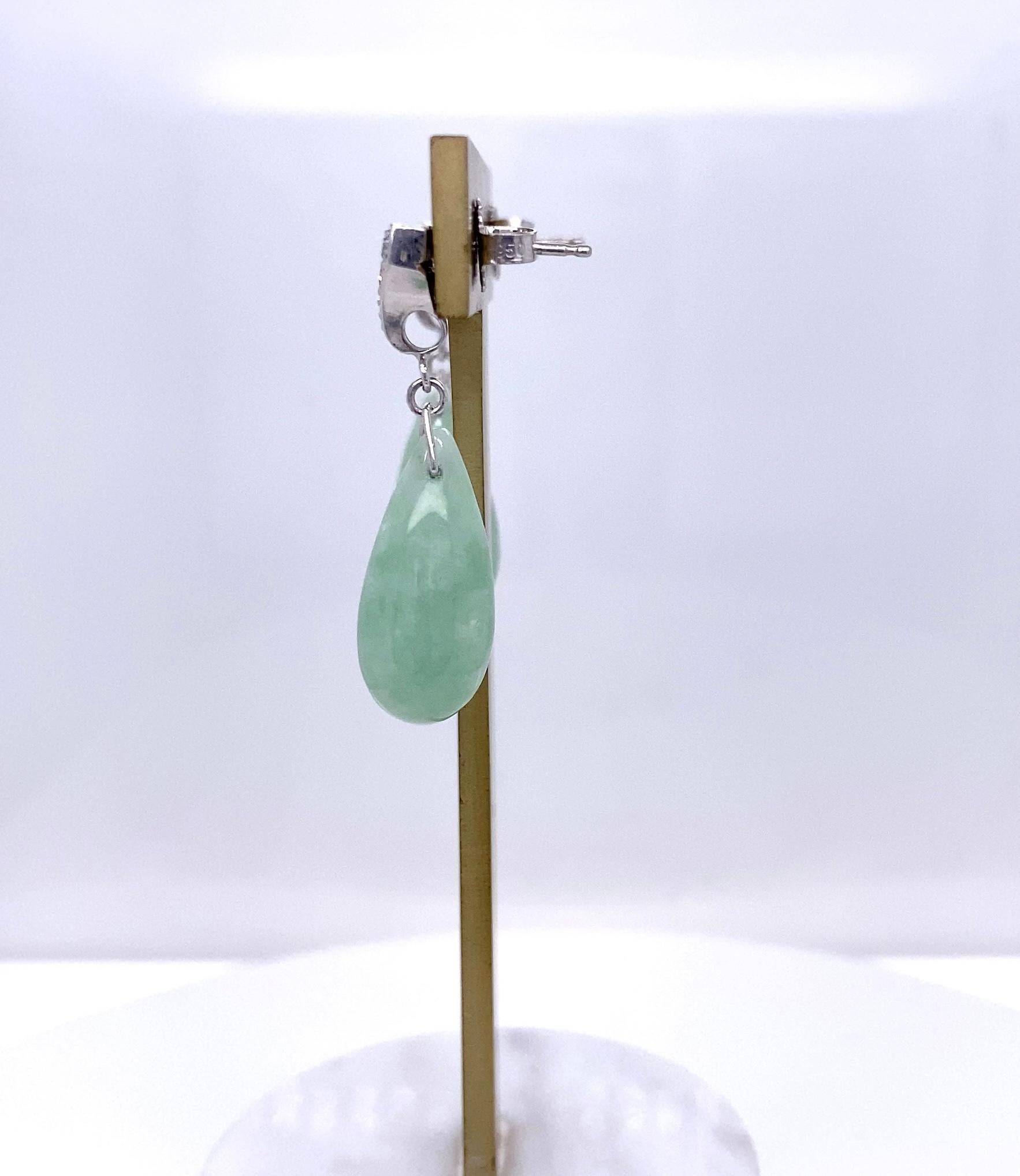 These elegant estate dangle earrings are crafted in platinum and beautifully blend Art Deco design with timeless gemstones. The diamond tops were repurposed from the original end links of an Art Deco platinum wristwatch, giving the pair a