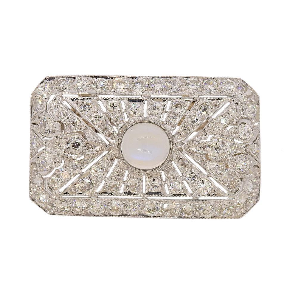 Rectangular platinum brooch pendant, set with 7mm center moonstone, surrounded with approx. 2.00ctw in diamonds. Brooch measures 36mm x 22mm. Weighs 9 grams.PB-01705