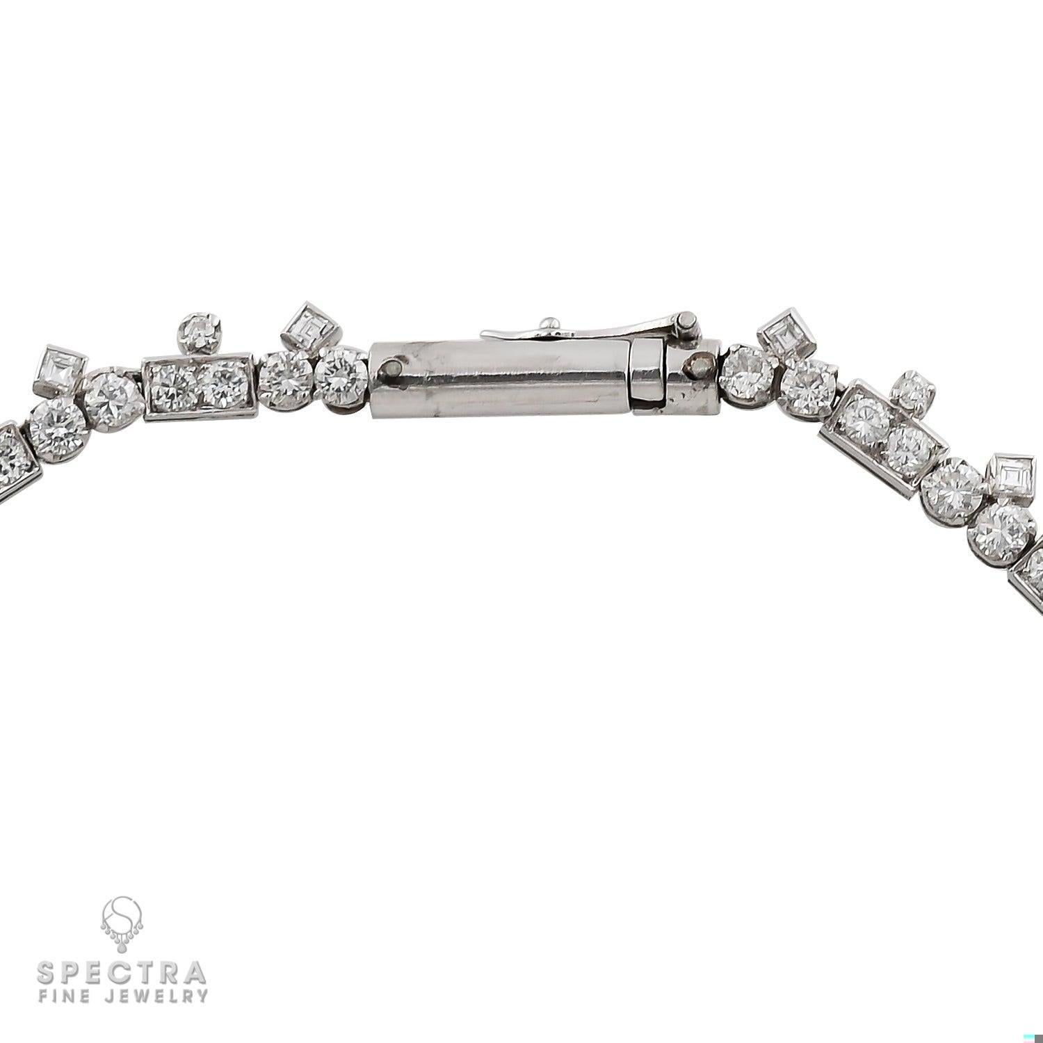This breathtaking platinum diamond necklace from the 1950s is a true masterpiece that transcends time. The necklace features an elegant combination of baguette and round diamonds, with the baguette diamonds in the swag section weighing approximately