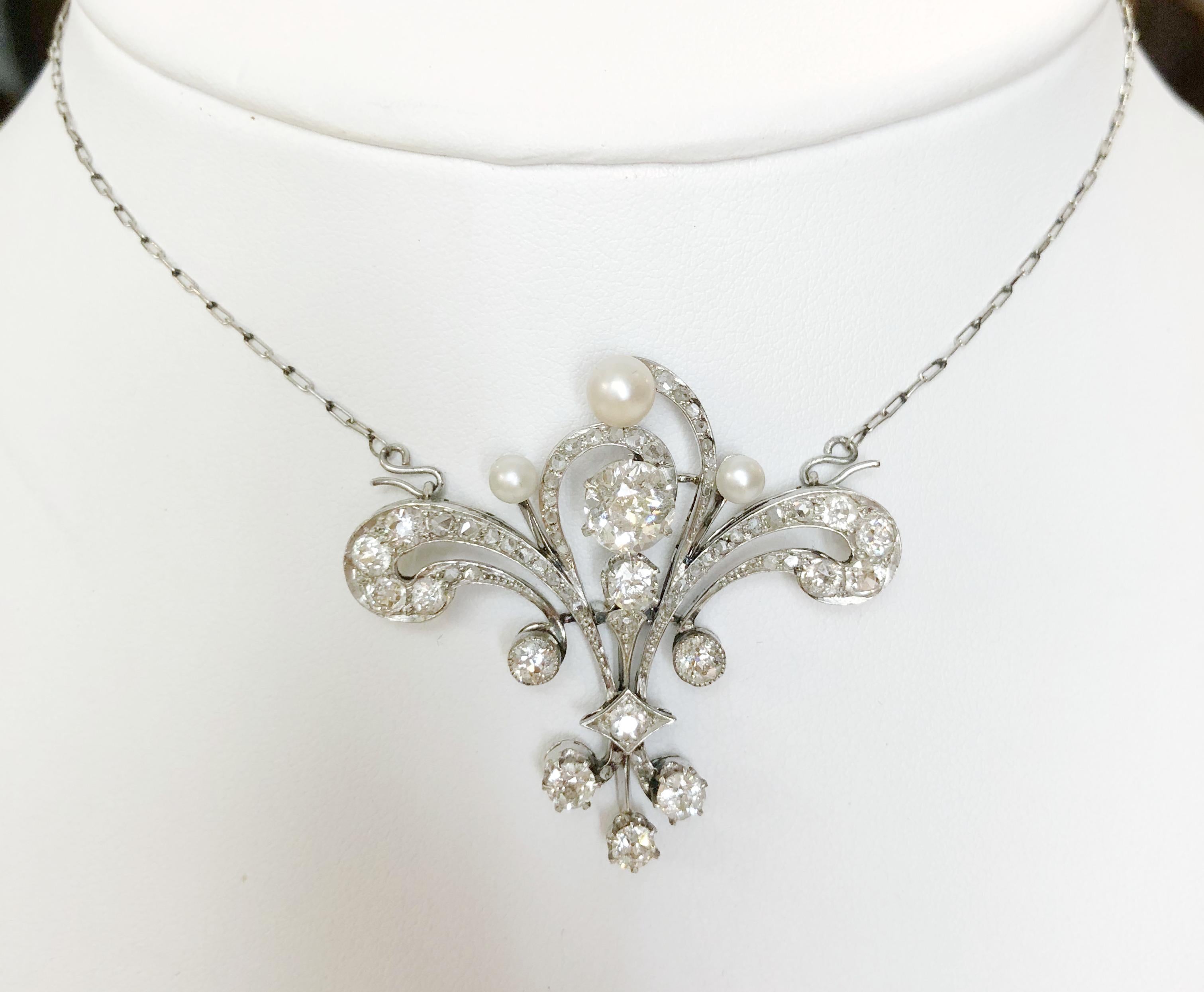 Vintage platinum necklace which also becomes a brooch, with natural pearls and a total 5 karats of diamonds, Italy 1920s.
The large center diamond is 1.75 karats in old-mine cut.
Length 53 cm
