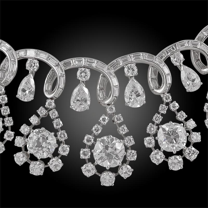 Ribbon design, set with drop shaped motifs framing cushion shaped-diamonds, highlighted throughout with brilliant-cut diamonds, further accented with pear shaped and baguette diamonds.
Inner circumference approx. 355mm