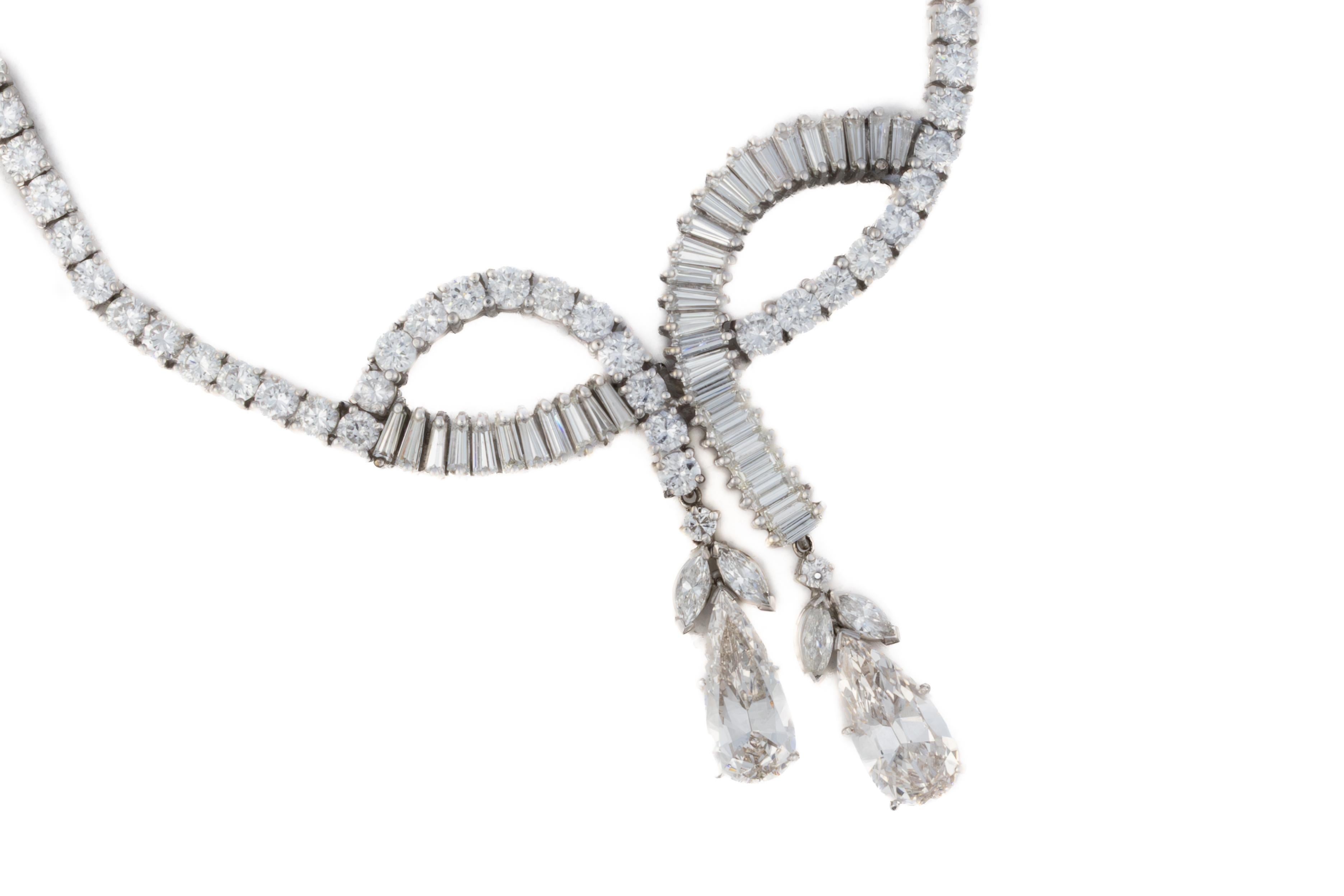 Platin-Diamantenhalskette mit spitz zulaufendem Baguette und birnenförmigen Tropfen

Beschreibung:
Ein elegantes, aus Platin gefertigtes Diamantencollier mit einer Reihe runder Diamanten im Brillantschliff, die zu einem skulpturalen Mittelstück auf