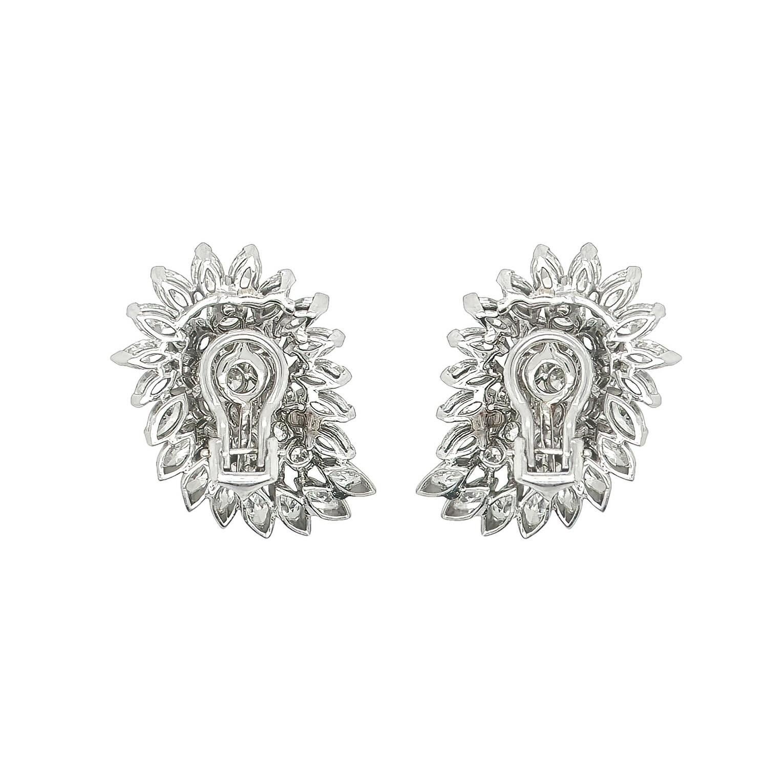 A pair of platinum and diamond earclips.  Each earclip designed as a cluster in a paisley motif set with approximately 20 marquise cut diamonds surrounding approximately 15 round brilliant cut diamonds.  Total diamond weight approximately 9.50