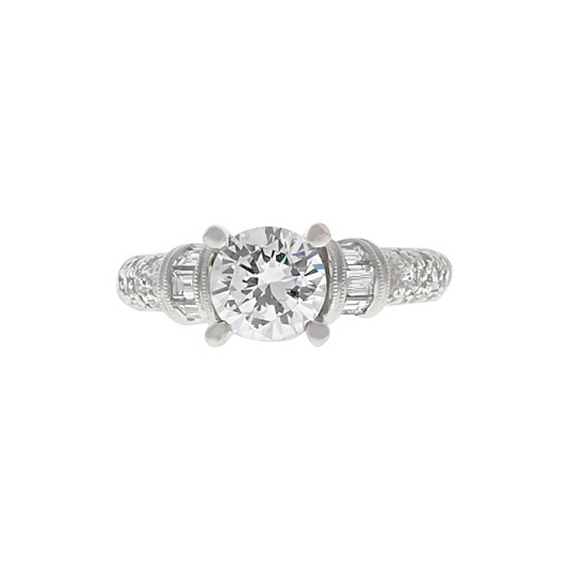 Platinum engagement ring containing one round brilliant cut diamond weighing 1.01 carats, G color, SI2 clarity. The mounting is set with baguettes and round pave diamonds weighing combined 0.67 carat.
This ring can be sized.
The center diamond is