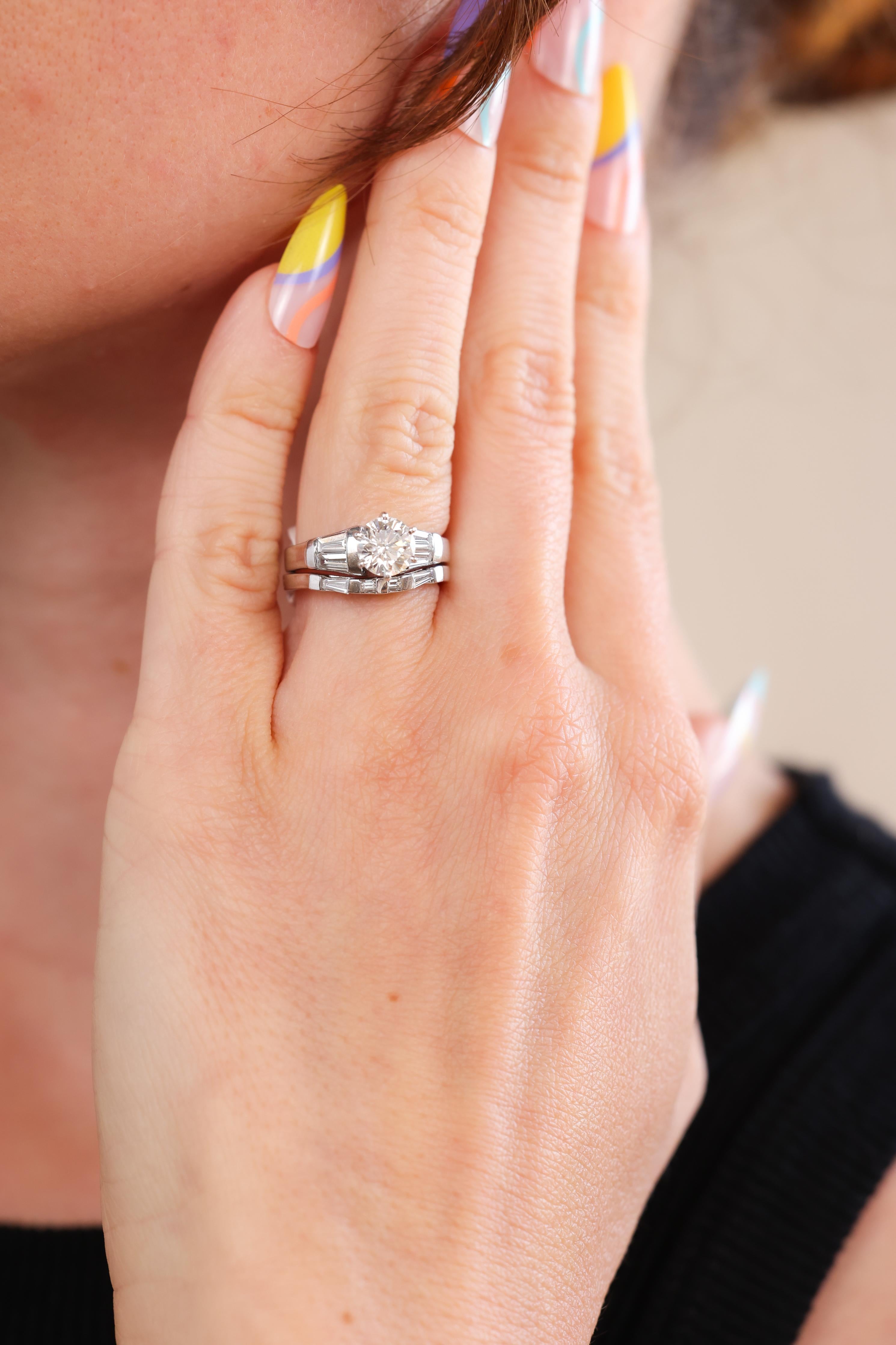 This is a beautiful and bright white platinum and diamond engagement ring set from the 1980s. The sleek matching wedding set showcases a nearly perfect six-prong set Round Brilliant Cut diamond accompanied by an EGL Diamond Report stating the 1.03ct