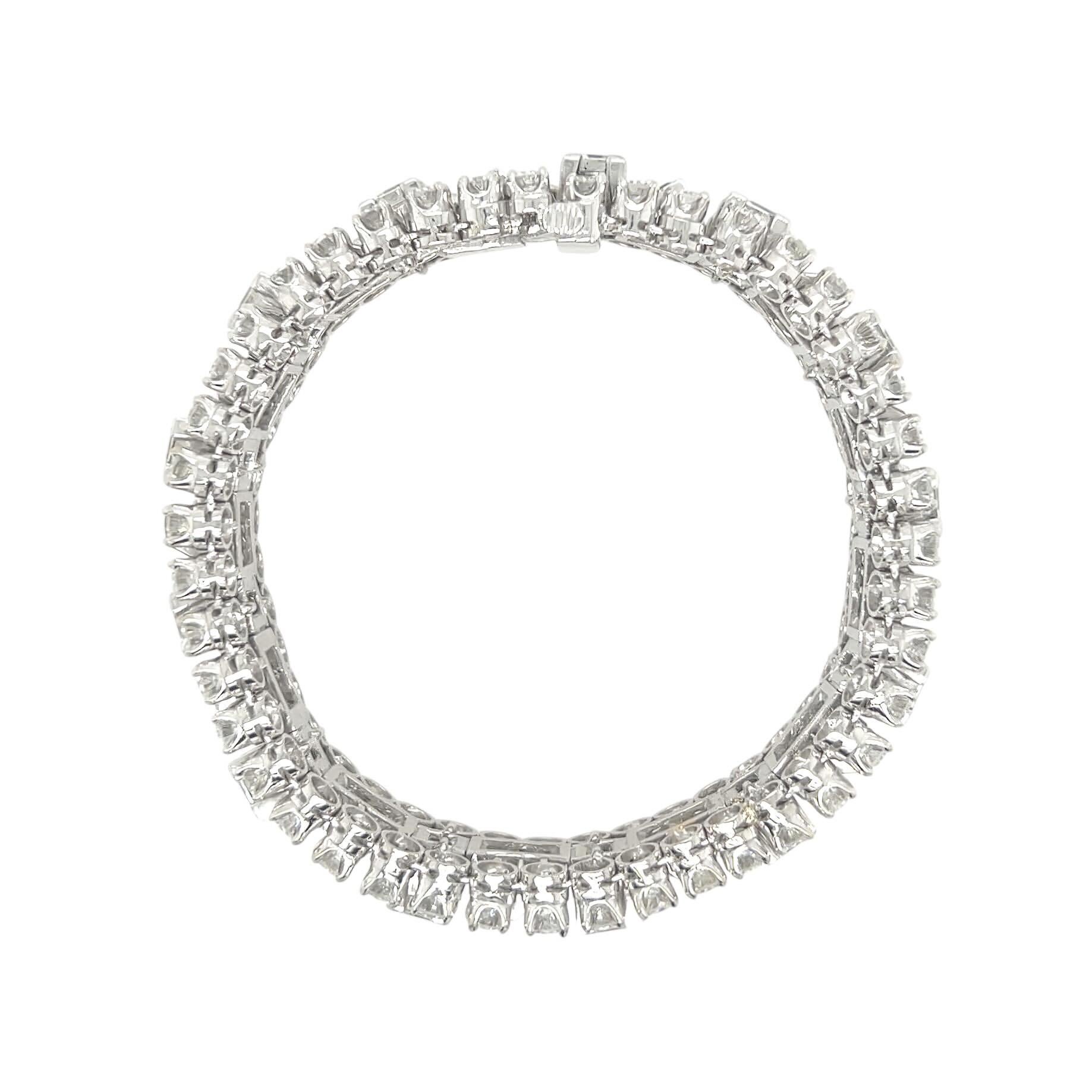 Una pulsera de platino y diamantes.  Diseñado como una línea recta que centra 13 diamantes rectangulares de talla escalonada alternados con 13 cuartetos de diamantes de talla baguette en parejas enmarcadas en A, los bordes exteriores engastados con