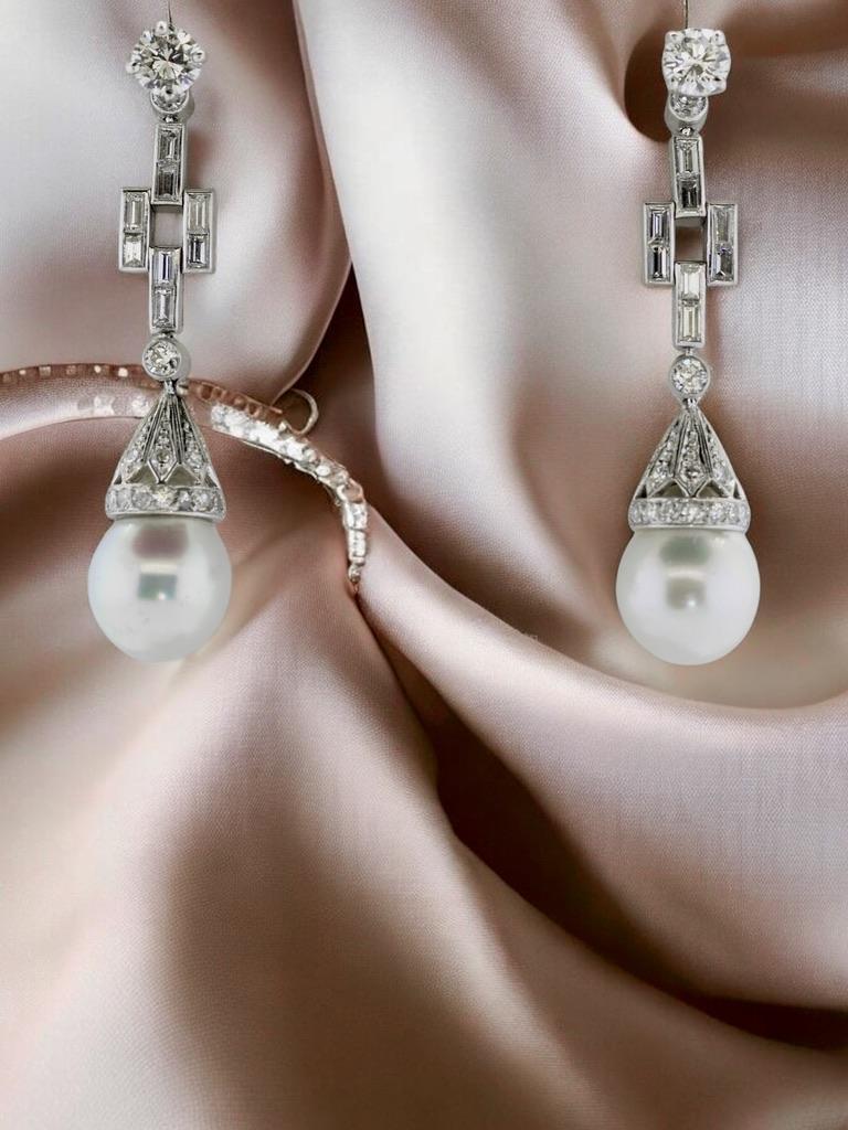 Platinum, diamond and pearl pendant style earrings. The hanging diamond and pearl portion can be removed so that one can wear just the top diamond studs. One can also wear a different type of stone at the top - such as a sapphire or ruby giving
