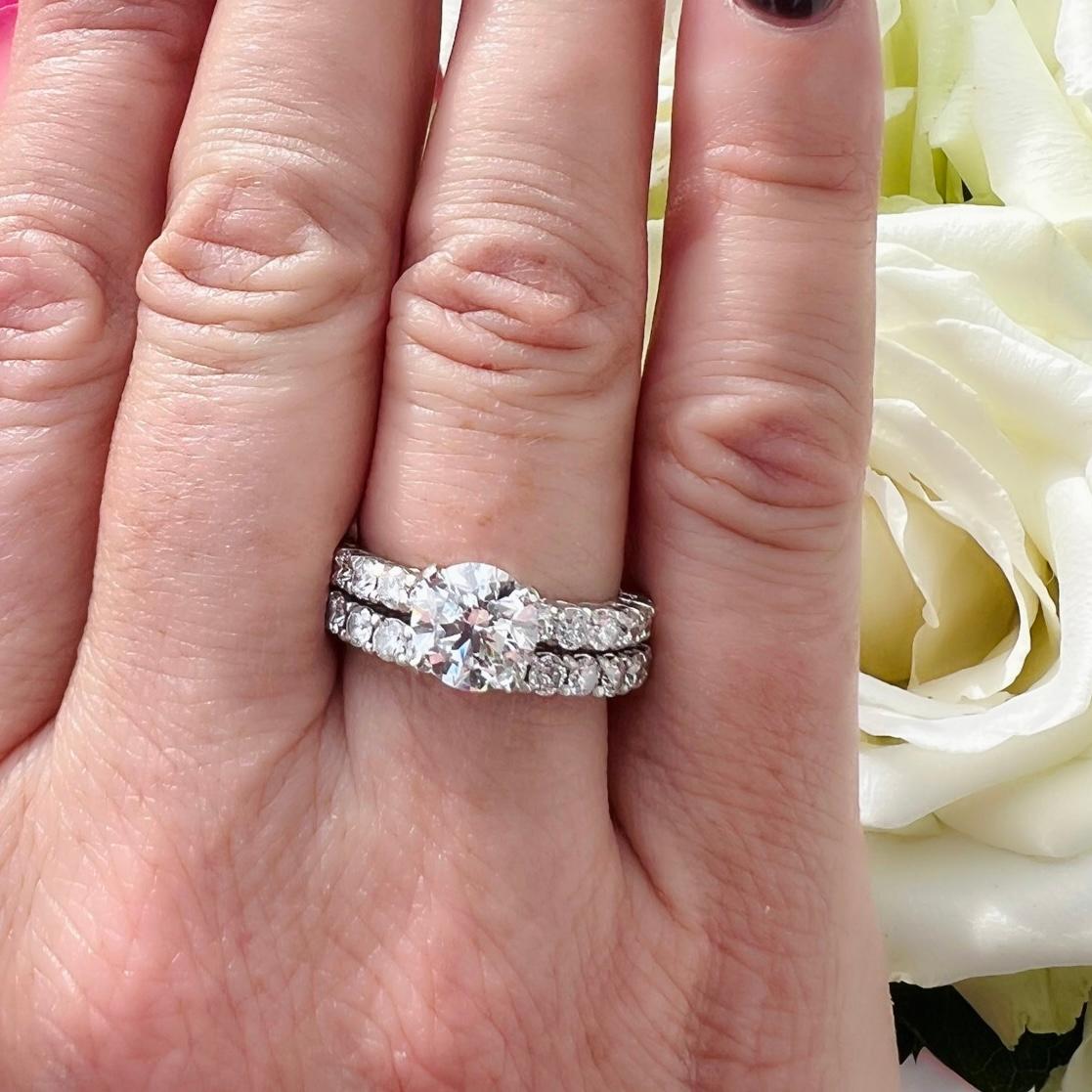 Una parure classica con uno splendido diamante centrale. Il fulcro di questa parure in platino è uno scintillante diamante rotondo taglio brillante da 1,65 carati in un anello a quattro punte con 12 diamanti più piccoli splendidamente abbinati e
