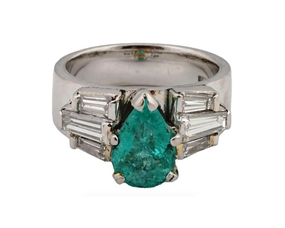 A vintage platinum engagement ring. The ring is encrusted with a pear cut Emerald stone in the center, and Diamonds on the sides. Marked with an impressed stamp, inside. Weight 7.5 grams. Vintage and Modern Diamonds Precious Stone Jewelry Wares and