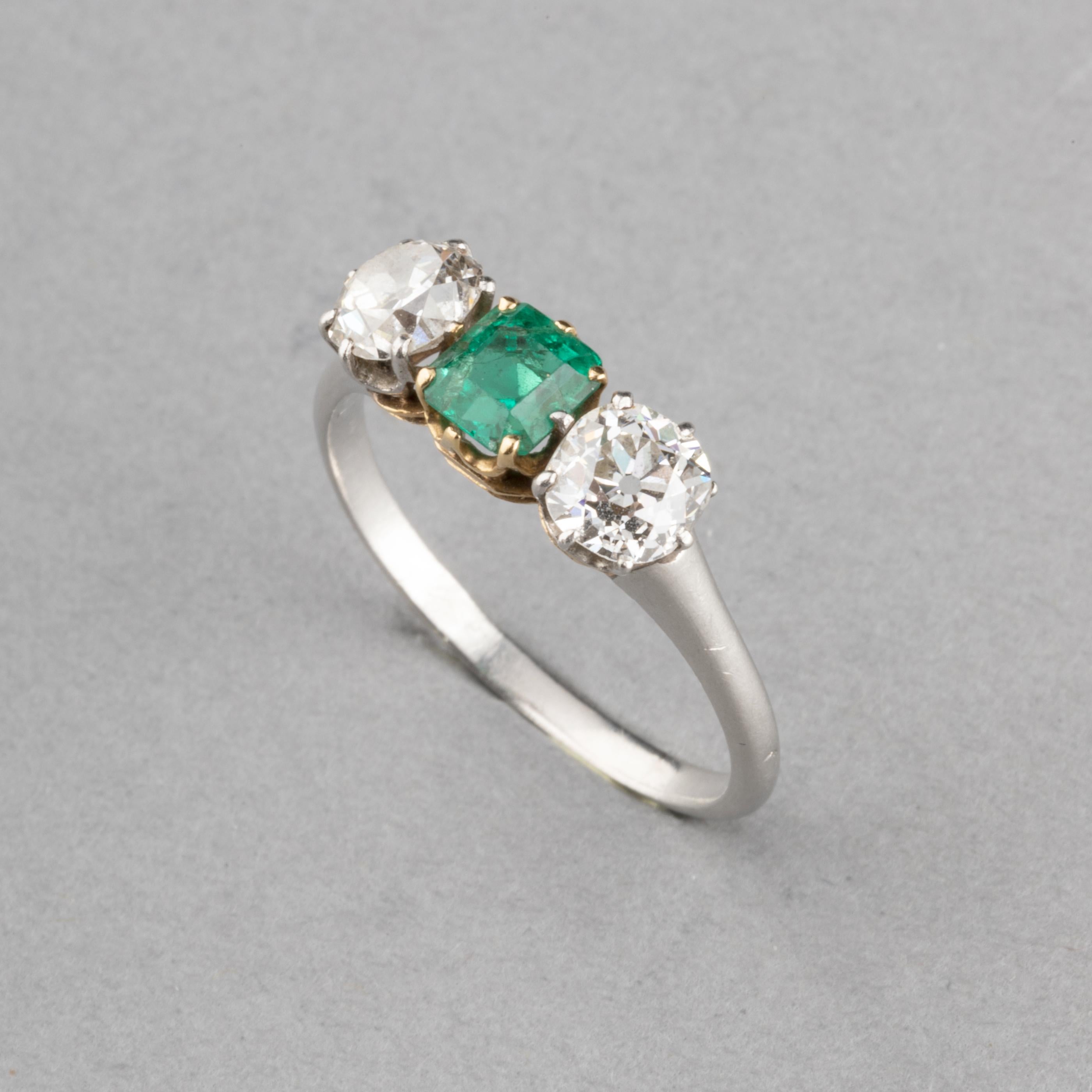 Platinum Diamonds and Emerald French Antique Ring

Beautiful antique ring, made in France circa 1920.
Made in Platinum (dog head mark) and 18k gold. Mark of the maker (unknown).
Set with two quality round old European cut diamonds.They 0.45 carats