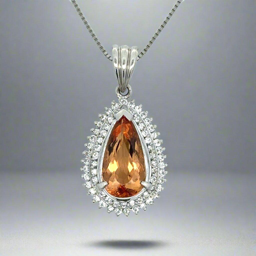 This Platinum, Double Halo Diamond and Topaz Necklace features a stunning, pear-shaped 4.16 carat topaz. The unique cut of the topaz offers a brilliant shimmer that captures the light and adds a touch of elegance to any outfit. Perfect for special