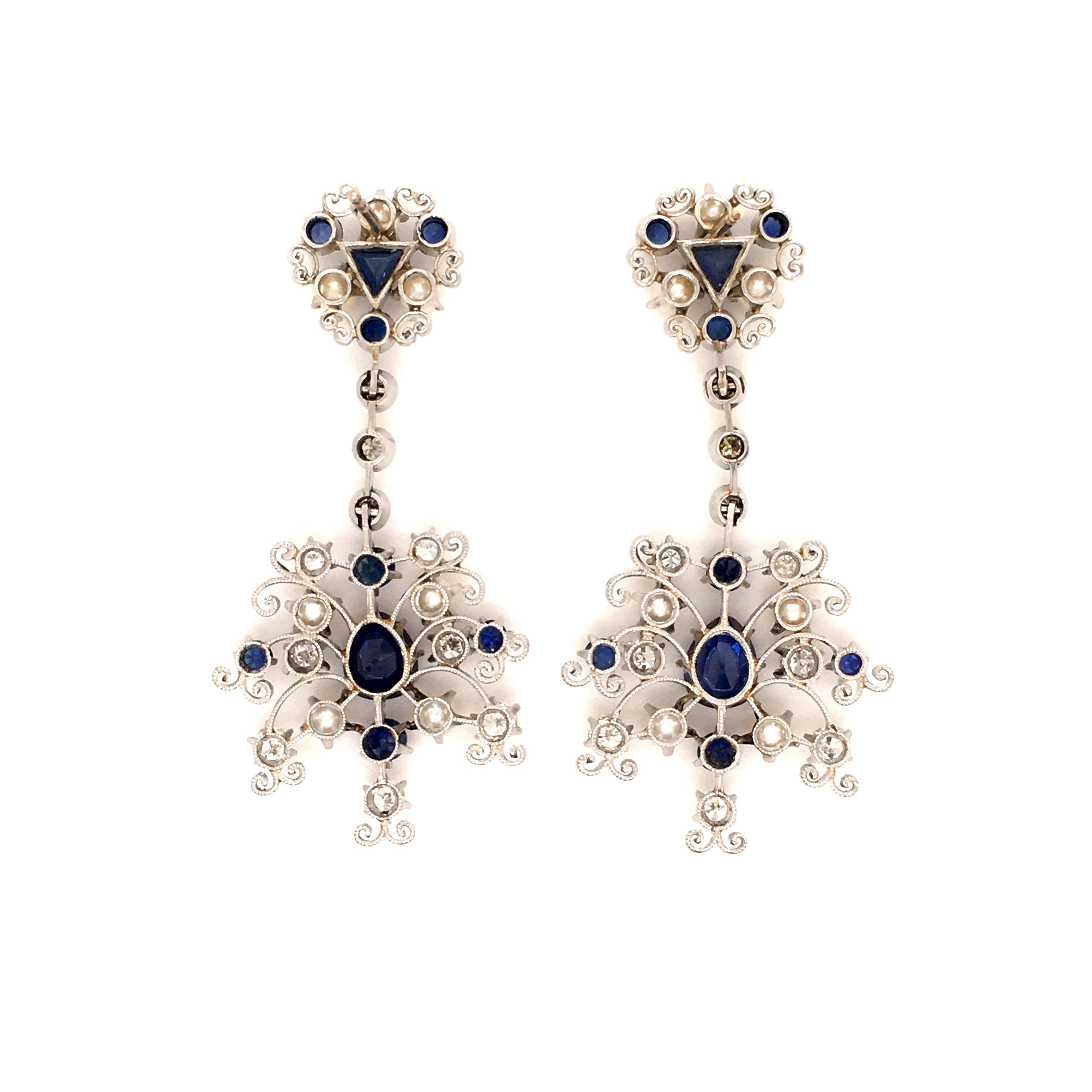 These snowflake like ear studs in platinum 950 are set with two pear shaped sapphires in the centre, total weight 2.50 carats, and 16 round and triangle cut sapphires, total weight 1.20 carats. In addition, there are also 14 round cultured pearls