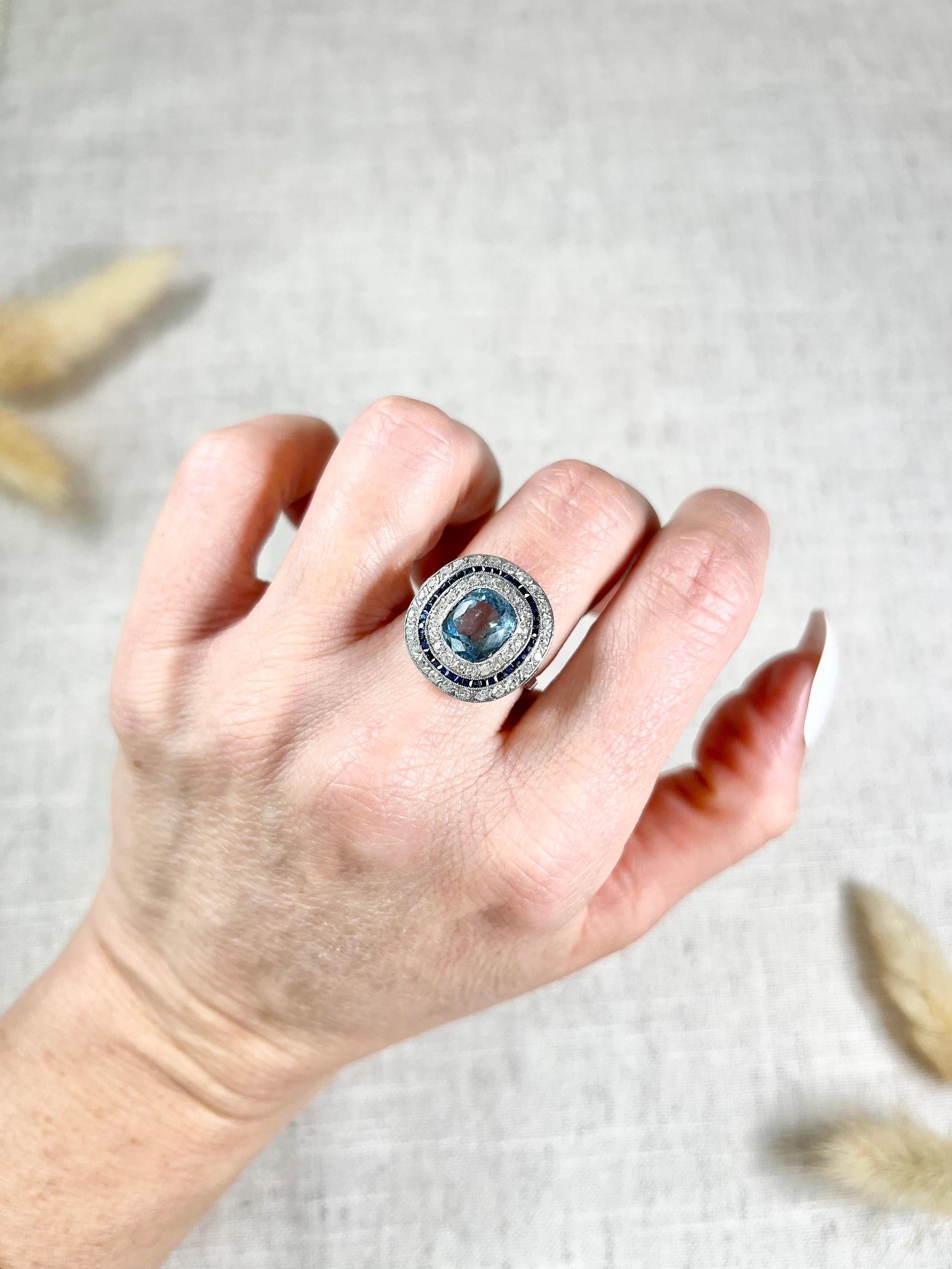 Antique Aquamarine, Diamond & Sapphire Ring 

Platinum Tested 

Circa 1910

This exquisite Edwardian ring is crafted from high-quality platinum and boasts a round shape design that is guaranteed to catch the eye. The centrepiece of the ring is a