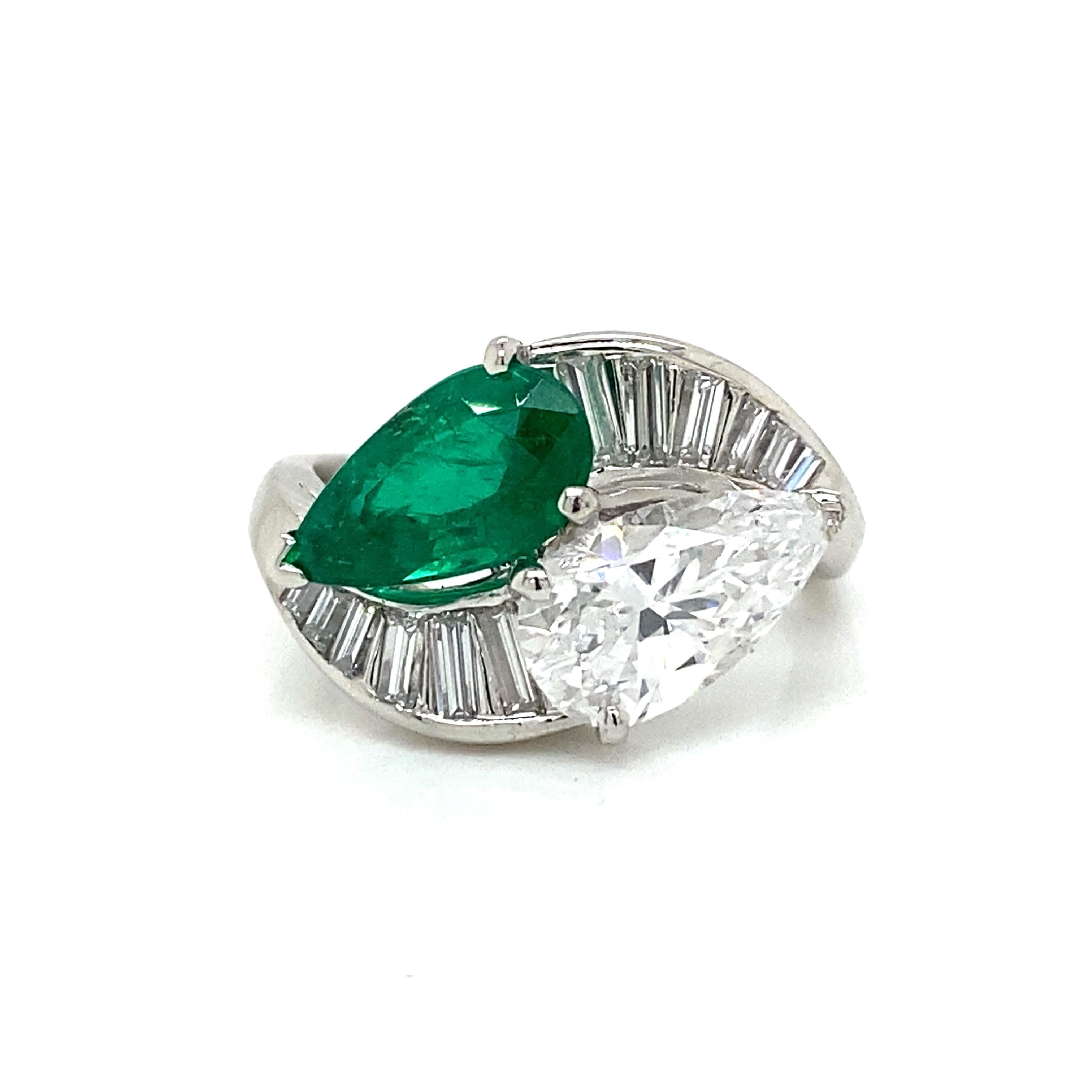 Emerald and Diamond Bypass Ring in Platinum.  (1) Pear Shape GIA certified Emerald weighing 1.61 carats and (1) Pear Shape GIA certified Diamond weighing 1.50 carats, D in color and VS2 in clarity are expertly set with Baguette Diamond weighing 0.33