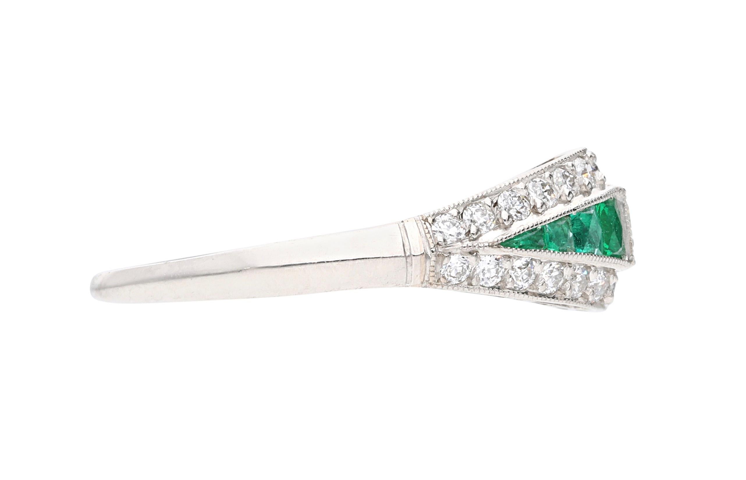 Centering a baguette-shaped diamond, this ring is accented by round brilliant cut diamonds and tapered emeralds.

- Center diamond weighs approximately 0.40 carat
- Round diamonds weigh a total of approximately 0.70 carat
- Platinum
- Total weight