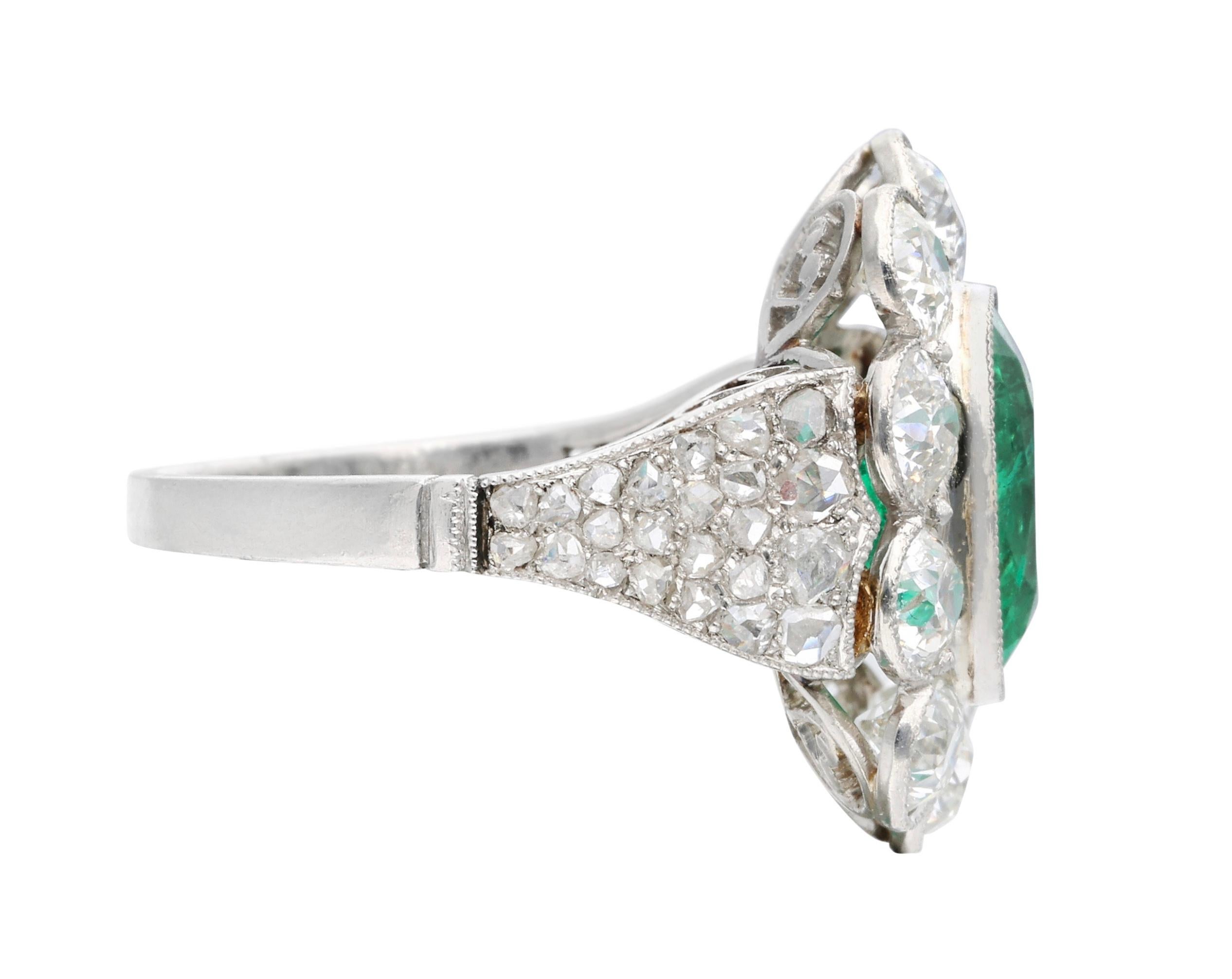 This ring features a cushion-shaped emerald, surrounded by 10 round old European cut diamonds with additional faceted diamonds on shanks.

- Emerald weighs approximately 2.60 carats
- Old European cut diamonds weighing a total of approximately 3.50