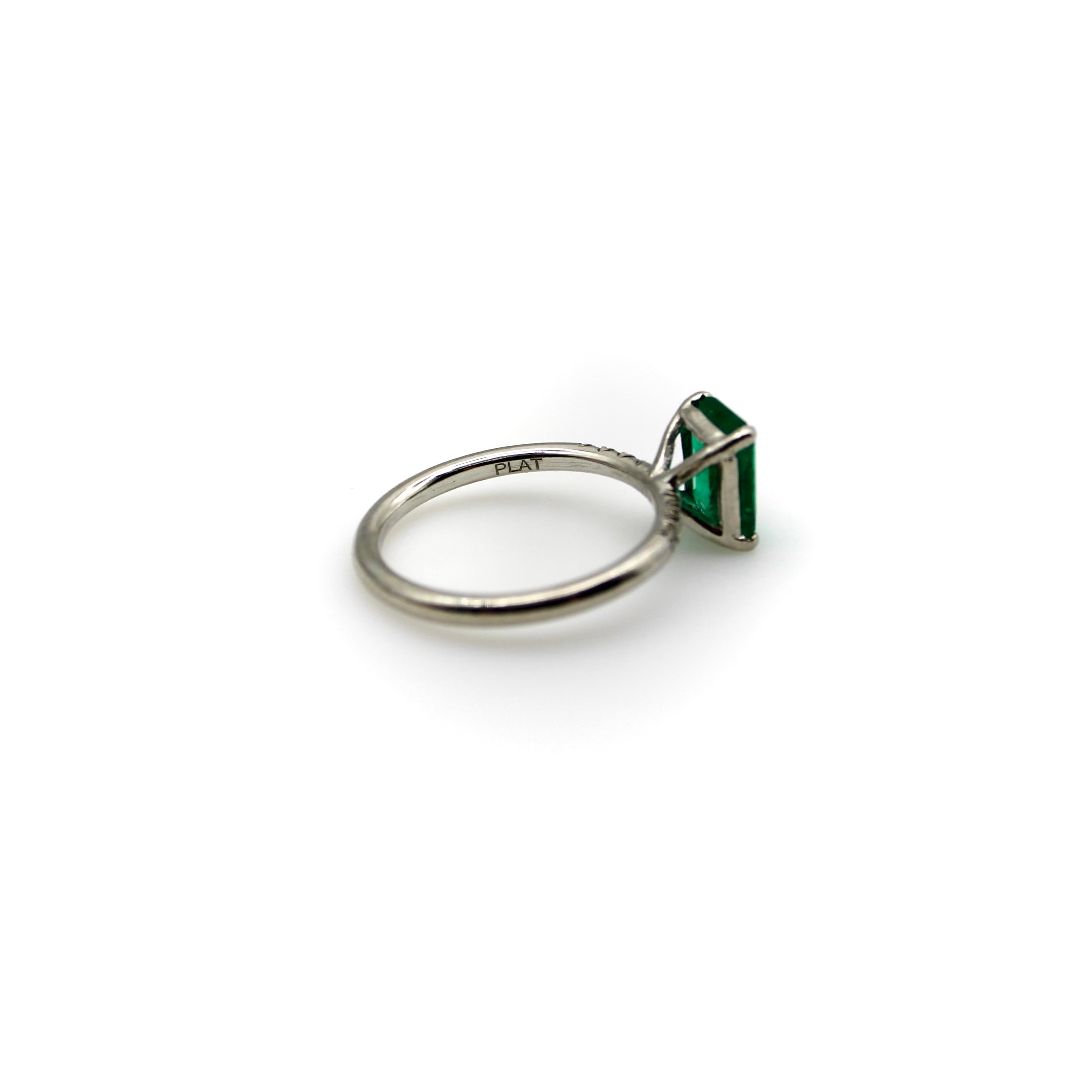 A beautiful rectangular emerald cut emerald is prong set into a platinum band, embellished with six single cut diamonds that add sparkle to the sides of the ring. The stunning natural emerald is 1.4 carats, well saturated and clear, making for a
