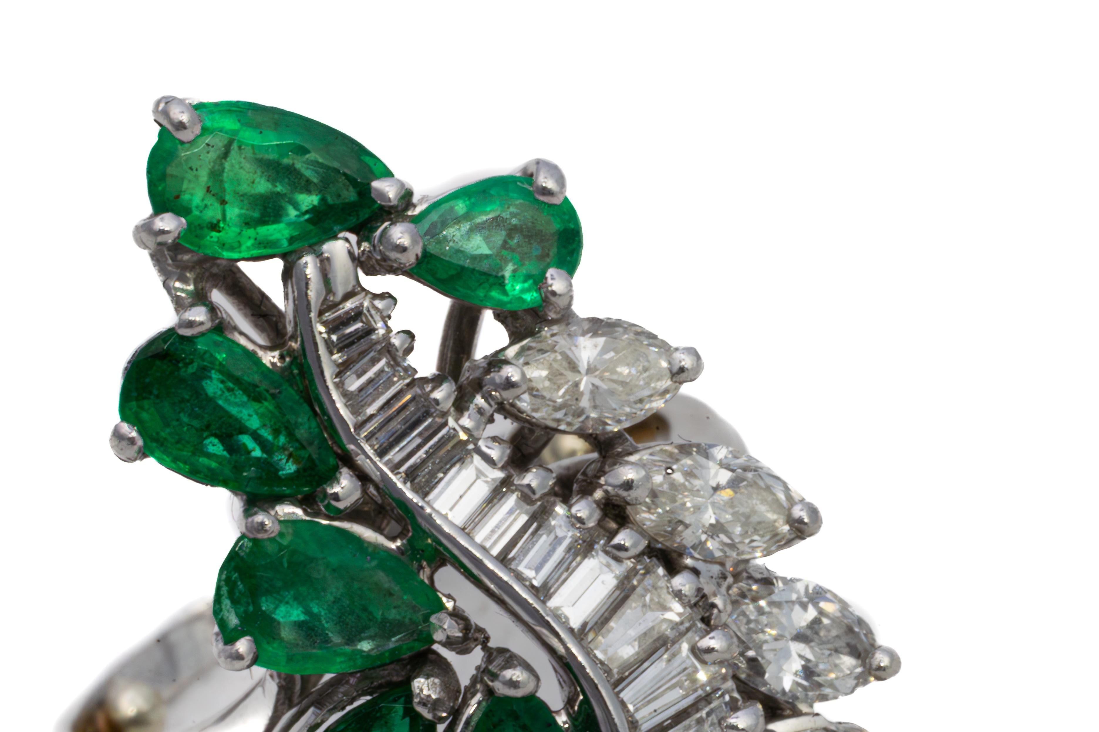 Platinum Emerald and Marquise & Baguette Cut Diamond Cocktail Ring

Description:
A bold cocktail ring crafted in platinum, designed with a sweeping composition of vibrant emeralds and sparkling diamonds. The ring is set with pear-shaped emeralds of