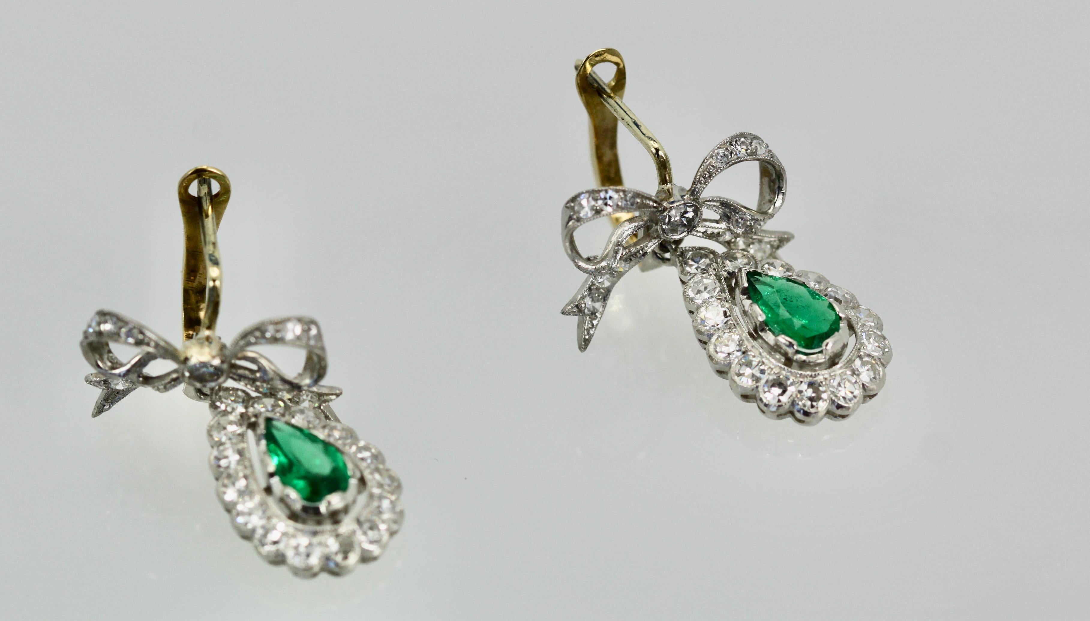 These platinum Earrings hold a beautiful Emerald.  They are from the Victorian period with there lovely diamond ribbon top and the surround of the Emerald is all in Diamonds.  These are small earrings and perfect for the petite women, but anyone can