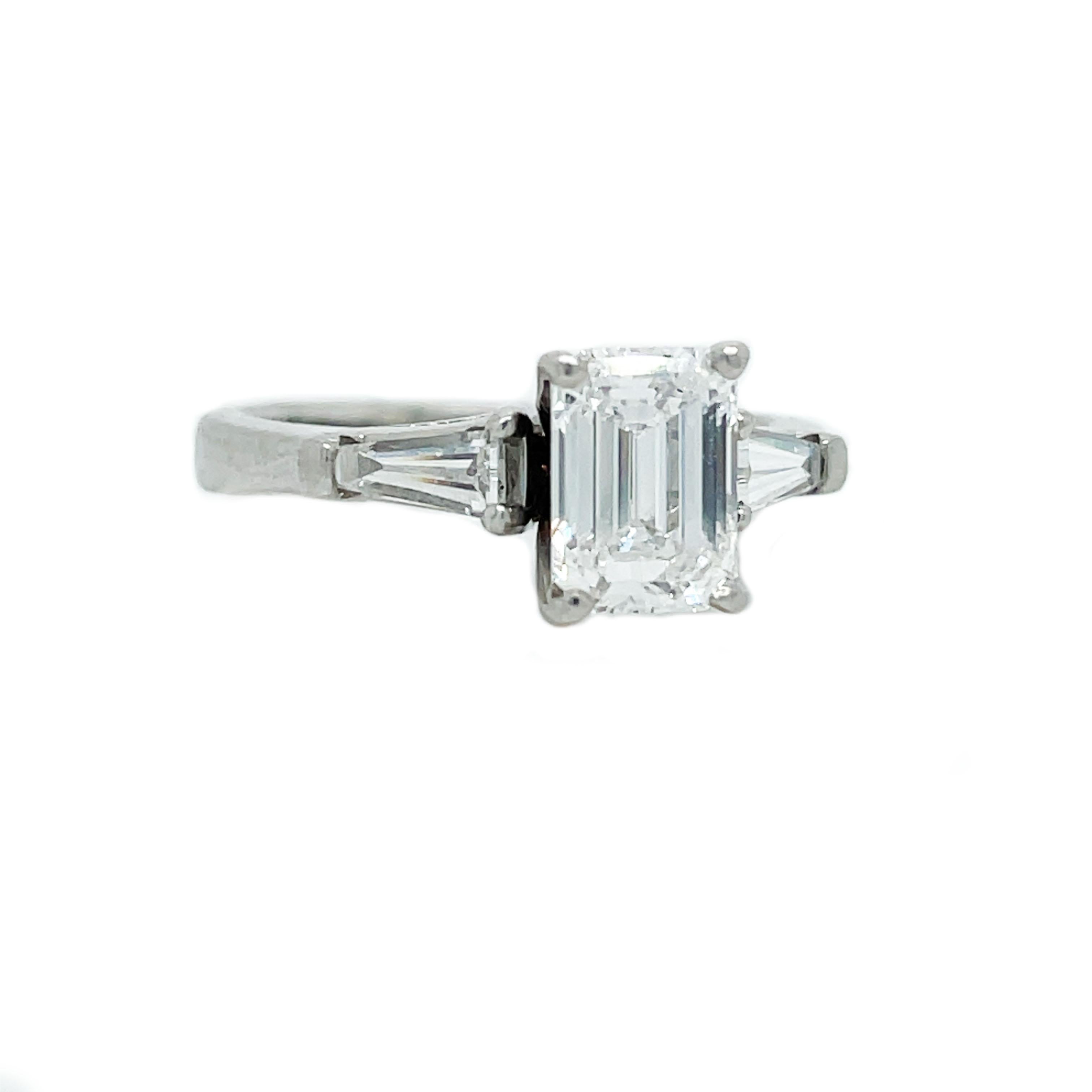 This is a killer Emerald and Baguette Diamond Engagement Ring set in Platinum GIA E VS1 Total weight 1.54ct. ! This ring highlights an icy white emerald-cut diamond cushioned between two shining baguette diamonds encased in a Platinum setting. This