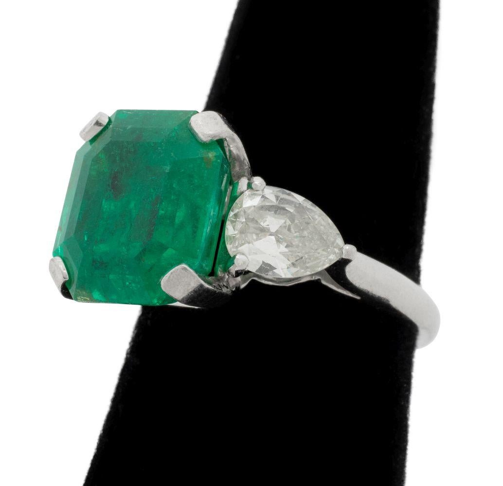 Anello in platino con smeraldo e diamante a 3 pietre, AGL, con uno smeraldo rettangolare sfaccettato a gradini incastonato del peso di circa 7,05 carati, incluso il rapporto AGL n. 1143203 datato 7 ottobre 2024, che dichiara che lo smeraldo è di