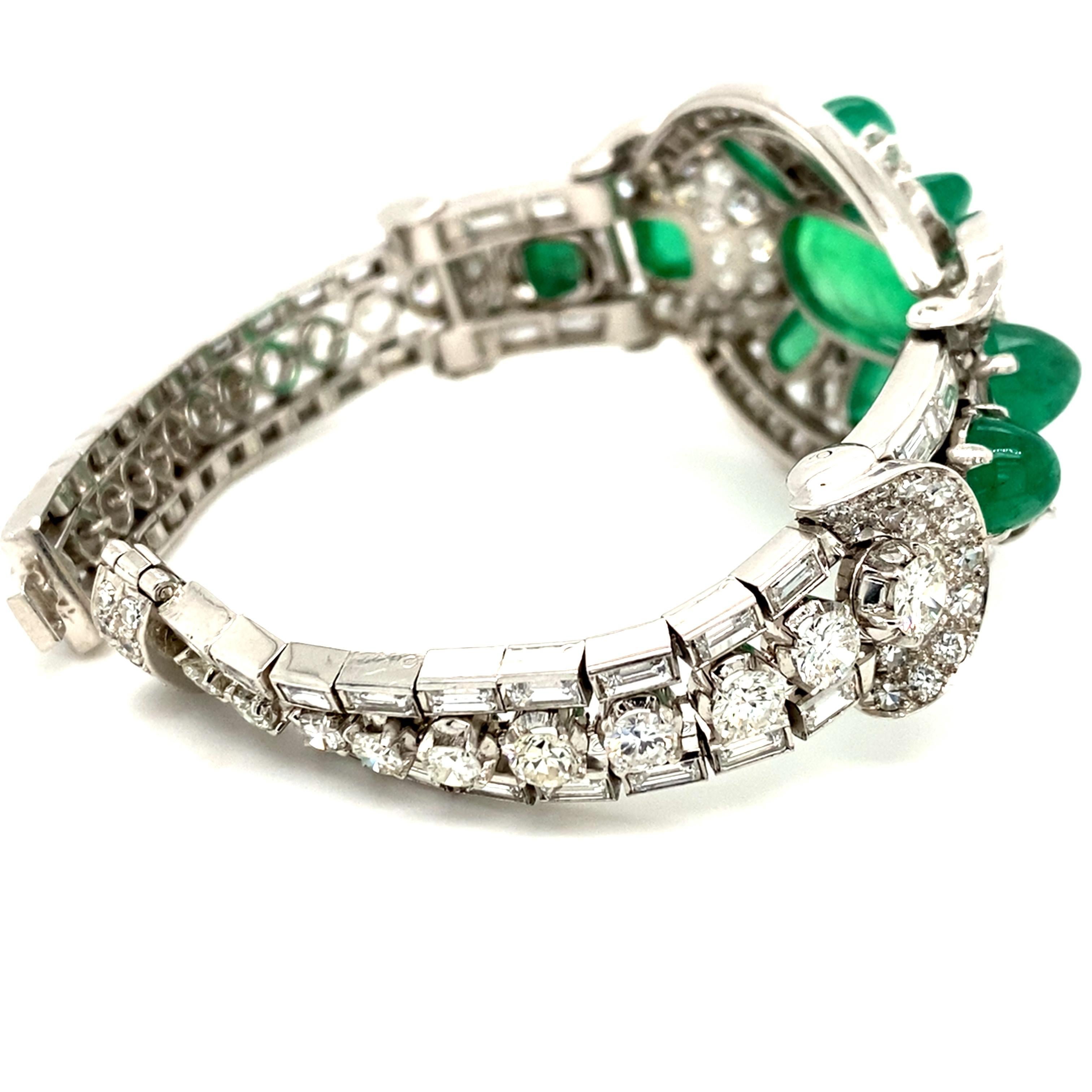 Platinum emerald diamond bracelet, circa 1950.
Opulent retro bracelet consisting of a big oval central motif flanked by three rows of round brilliant-cut diamonds and diamond baguettes. The oval motif features a large oval emerald cabochon