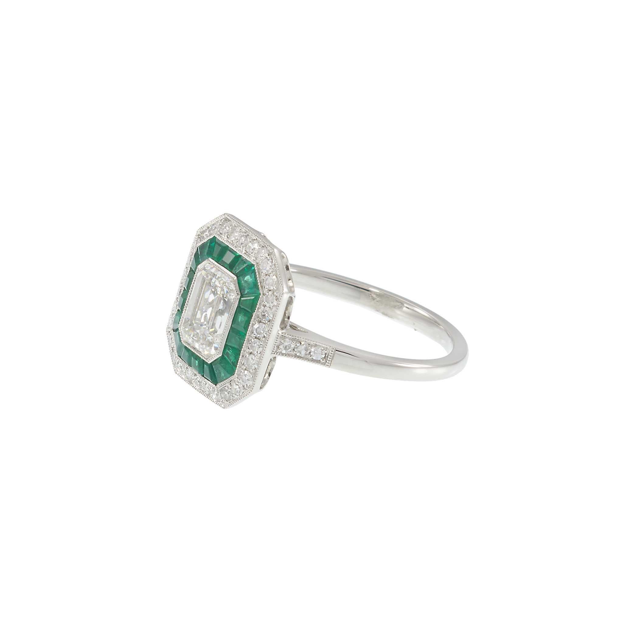 A striking balance of vintage glamour and refined design, this platinum ring centers a GIA-certified emerald-cut diamond encircled by a geometric halo of vivid green emeralds and additional round brilliant diamonds. The precision of the emerald cut