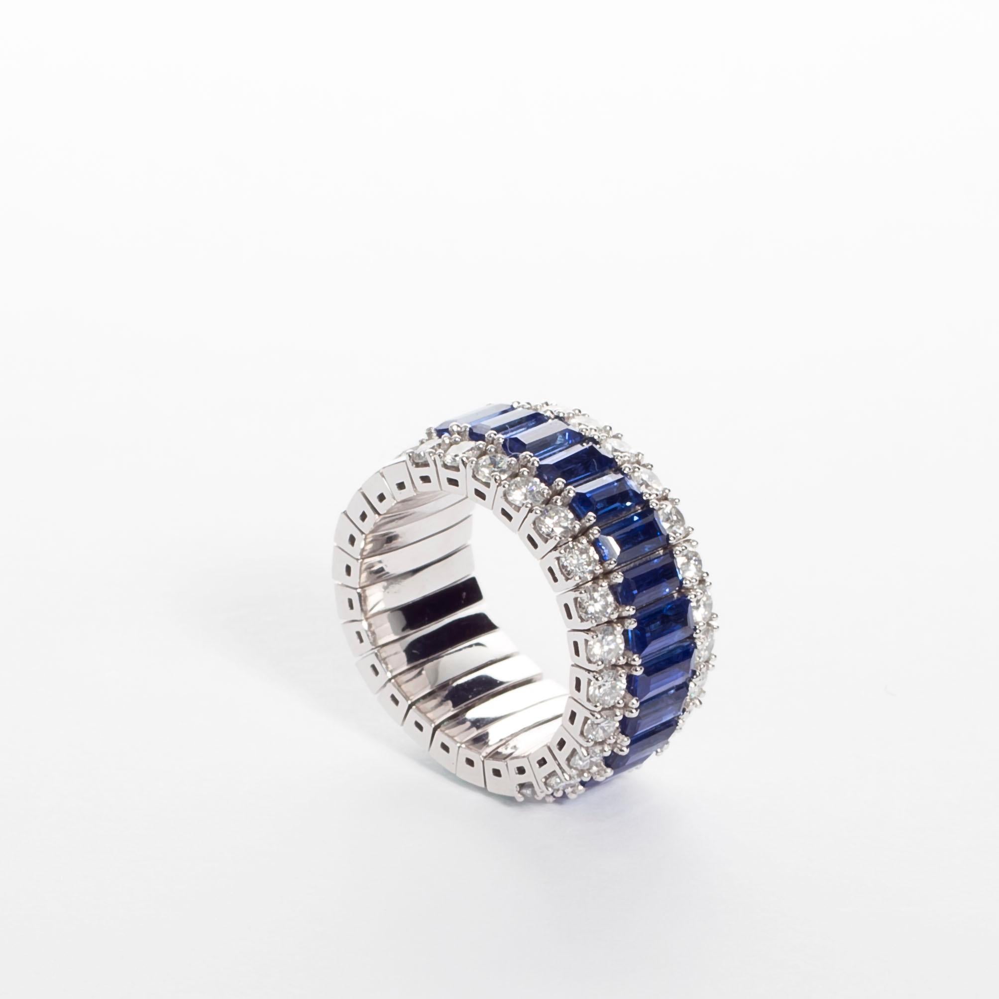 Indulge in our platinum flexible ring, a breathtaking symphony of emerald, sapphire, and diamonds. This exquisite piece boasts 13 blue sapphire baguettes totaling 3.83 carats, 13 diamond baguettes totaling 2.23 carats, 26 brilliant-cut diamonds
