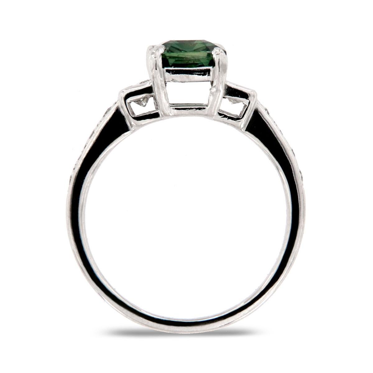 This Delicate platinum ring features a 1.37-carat emerald shape Sri Lankan None Heated Teal color sapphire flanked by two perfectly matched princess shaped natural diamonds and a row of pave set melee diamonds on each side. This stunning ring is