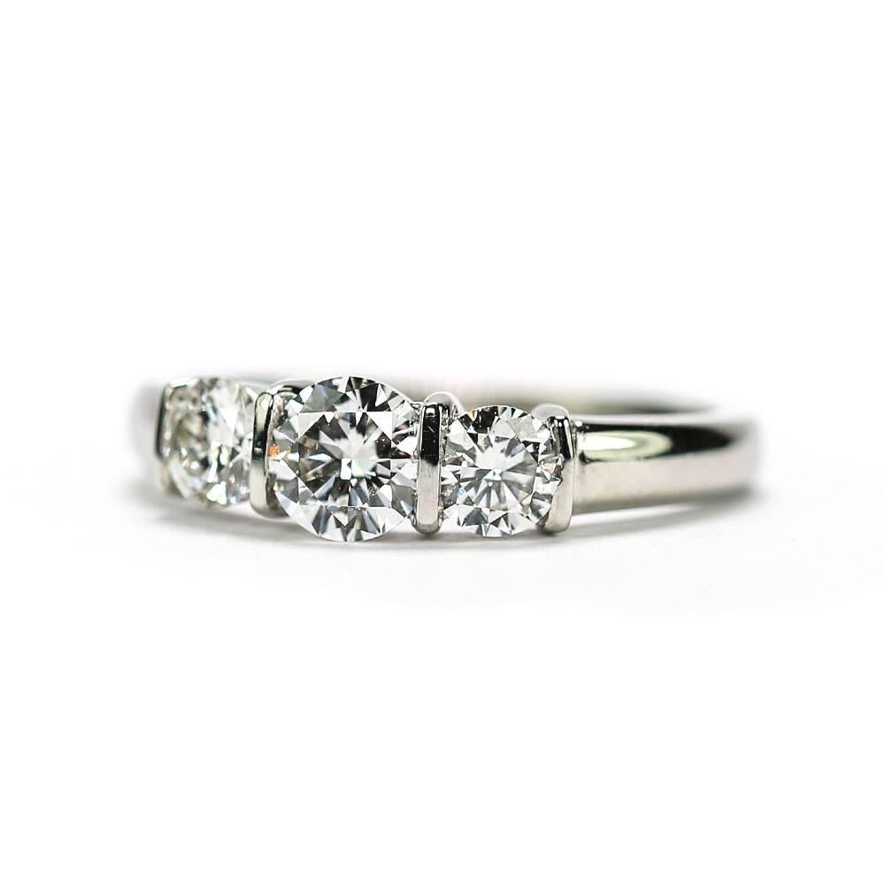 A modern three stone bar set platinum diamond ring, comprising of 3 graduated brilliant cut diamonds totalling an estimated 1.25cts. The centre stone est. 0.55ct flanked by two stones est. 0.35ct are all of good colour F-G and sit well in the thick