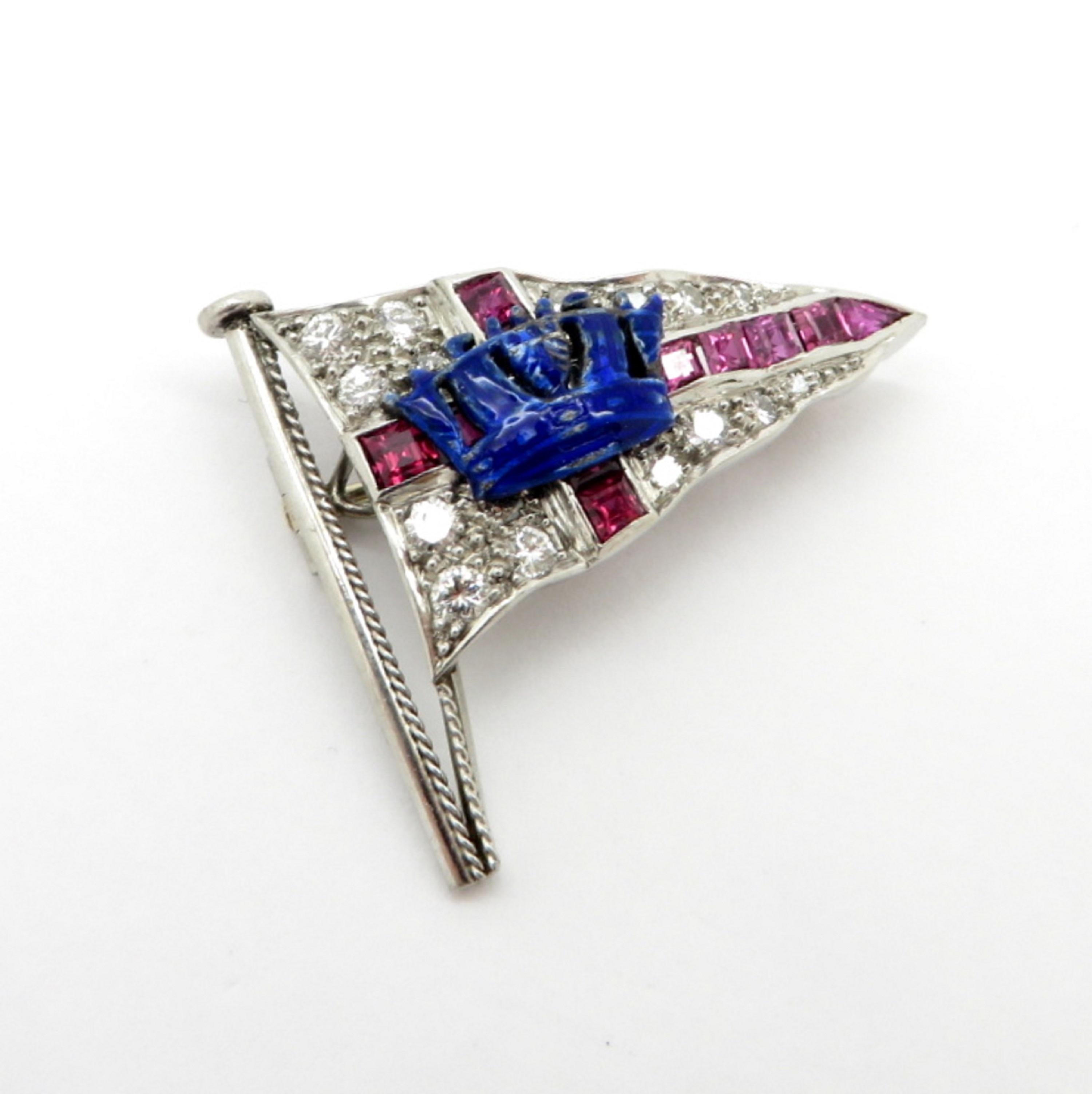 Platinum estate crown flag brooch pin with diamonds, enamel, and synthetic rubies. Featuring a blue enameled crown in the center and 12 carre cut synthetic fine quality rubies. Interspersed with 18 round brilliant cut diamonds weighing approximately