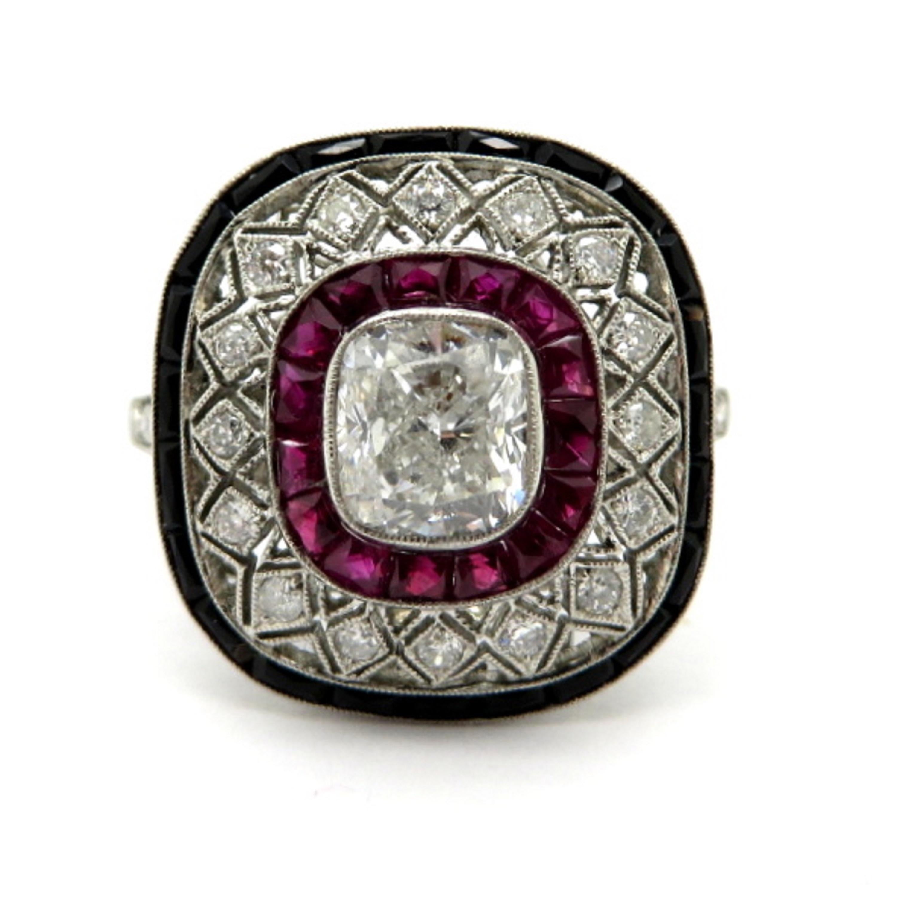 Platinum estate cushion diamond, ruby, and onyx  antique ring. Centering one cushion cut diamond weighing 1.01 carats, having H color grade and I1 clarity grade. Accented with 15 French cut 
fine quality rubies and a border of French cut black onyx