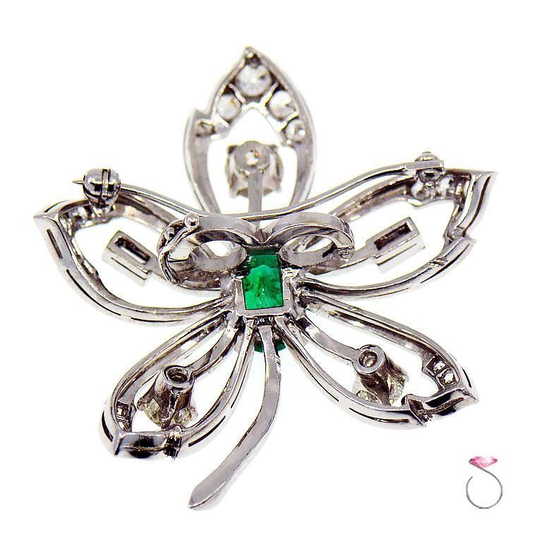 This stunning single flower double function, brooch and Pearl strand enhancer, is artfully crafted in platinum and encrusted with a beautiful 2.10 ct. green Colombian emerald at the center. Surrounded by five open center petals. Three of the petals