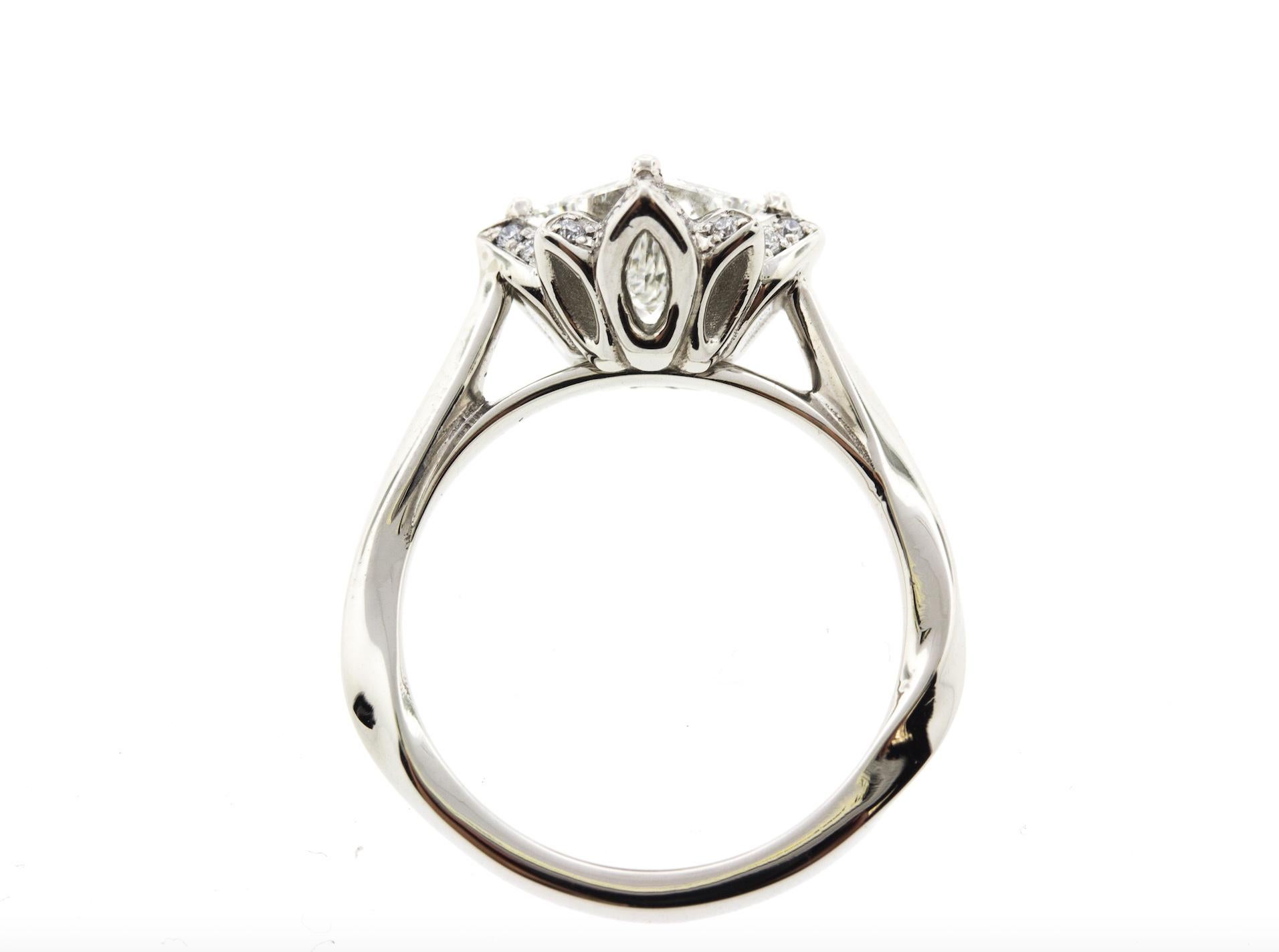 This platinum flower engagement ring is inspired by nature and features a princess cut diamond in the center.  Crafted in Platinum, this flower ring contains a Princess cut Diamond (1.00 total carat weight, G color, SI2 clarity) and is surrounded by