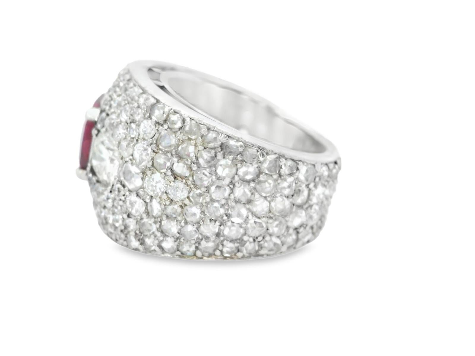This striking ring features a bold design, centered around a captivating red  No Heat ruby. The oval-cut ruby is surrounded by a dazzling array of white diamonds, enhancing the ring's opulent appearance.

Crafted in platinum, the piece boasts a