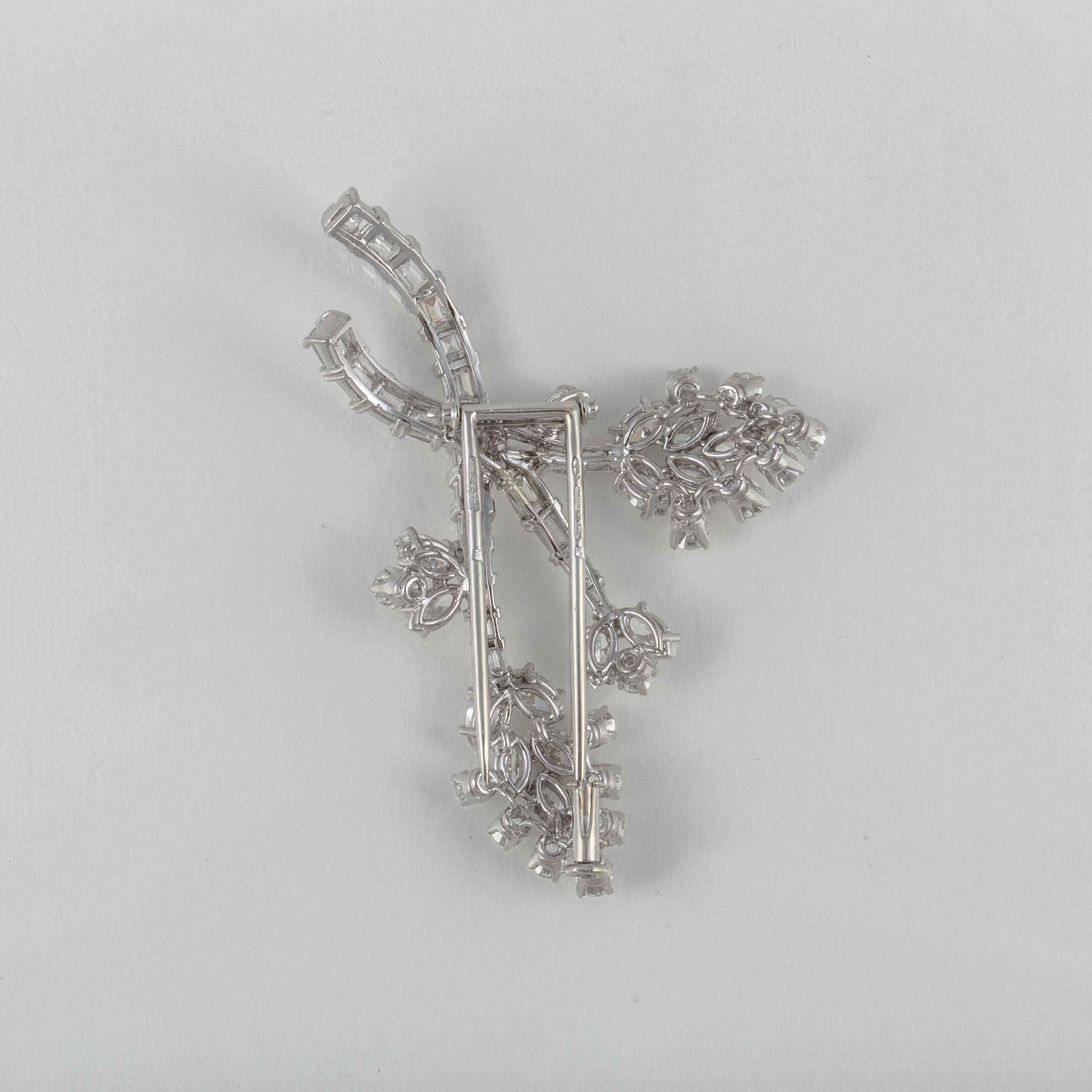 Platinum brooch featuring a spray of round, baguette and marquise diamonds.  There are 16 round diamonds that total 1 carat, 25 baguette diamonds that total 2 carats and 15 marquise diamonds that total 2 carats.  Total diamond weight of the brooch