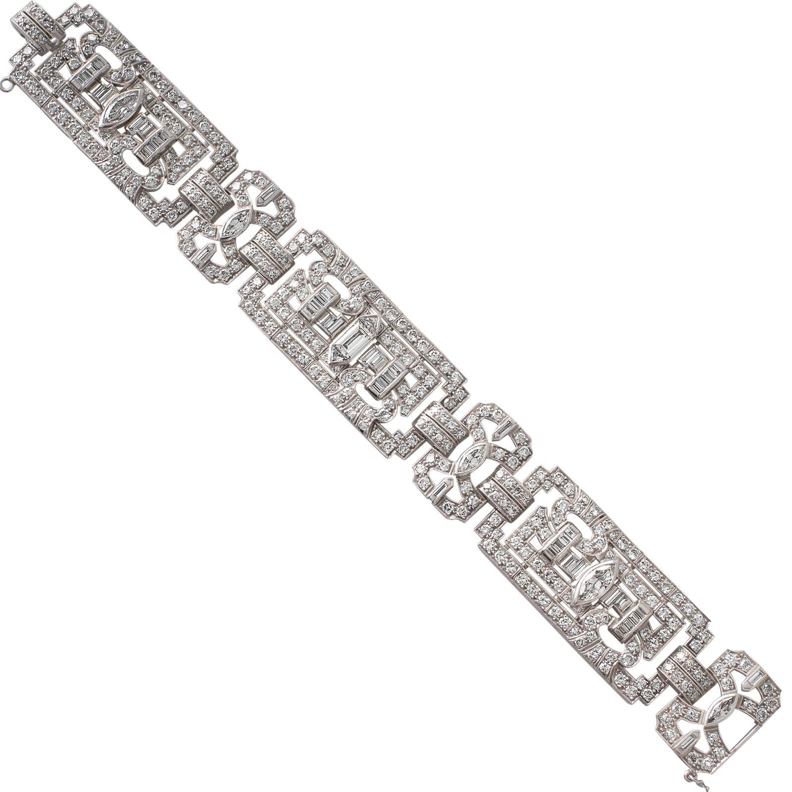 A platinum Art Deco bracelet of geometric design with articulated panel shaped links set with a combination of baguette, marquise, trilliant and round early brilliant cut diamonds fastening with a clip style catch and safety chain.
Total Estimated