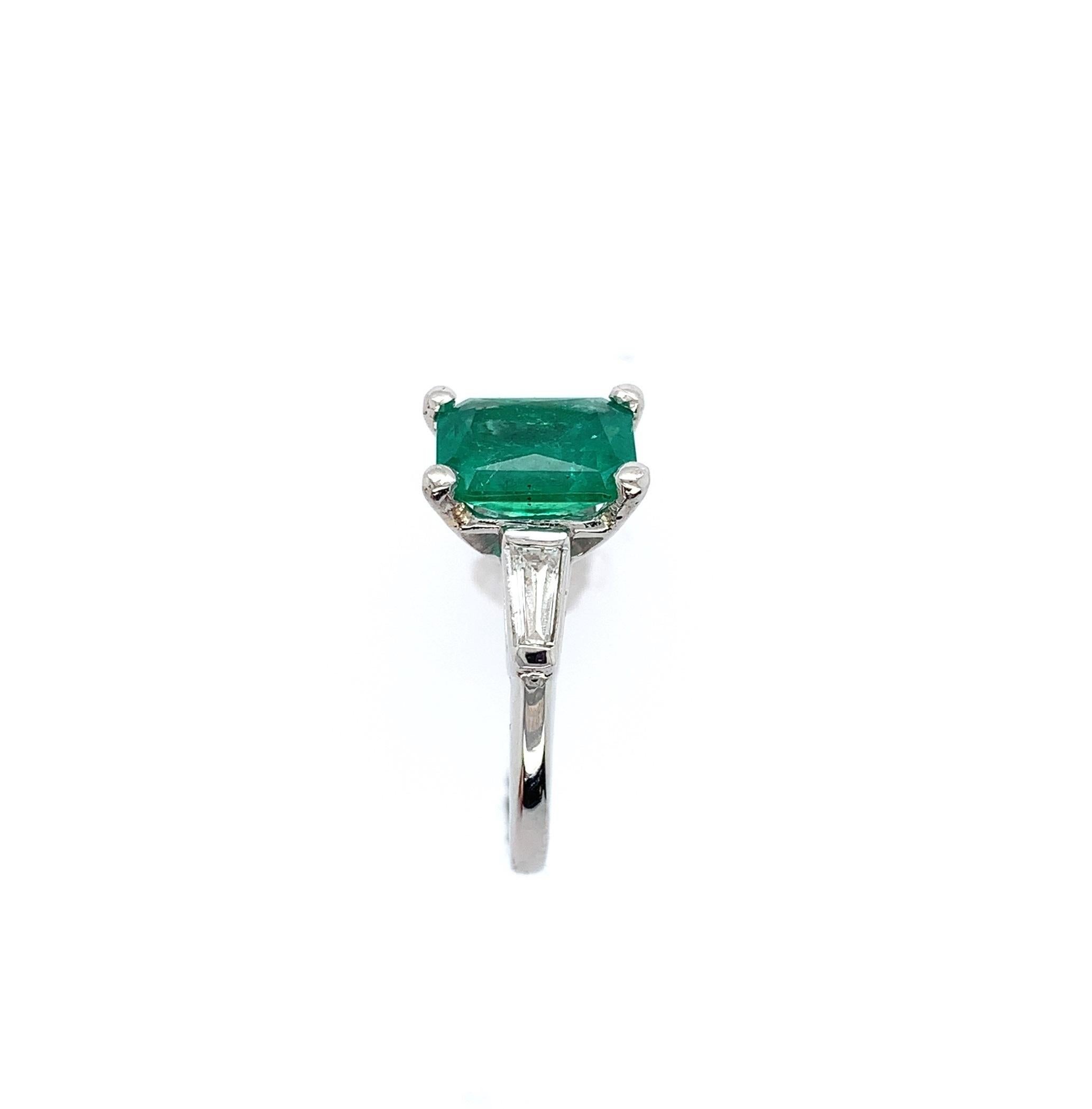 Platinum emerald and diamond ring featuring a genuine earth mined emerald weighing 1.87 carats with GIA report #5222332952. The report states it is an octagonal brilliant cut measuring 8.58mm x 6.63mm x5.24mm. The emerald has bright grass green
