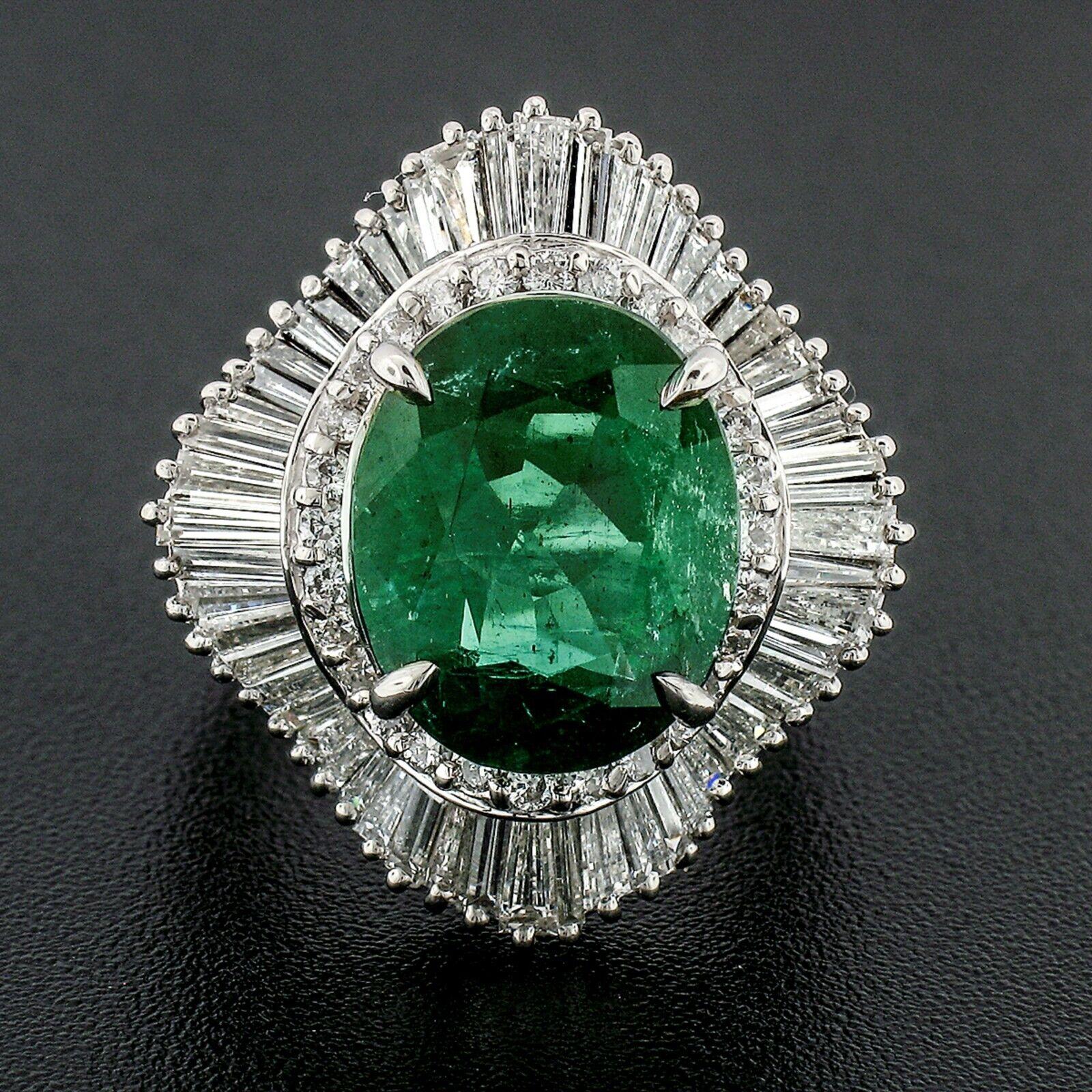 You are looking at a truly breathtaking emerald and diamond ballerina-style statement ring crafted from solid .900 platinum. The large oval cut emerald is prong set at the center of the ring and is GIA certified as being a natural mined stone from