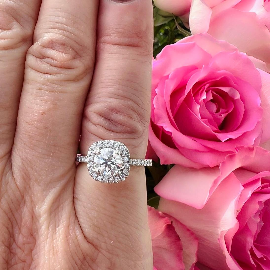 A near perfect diamond falls right into place in this gorgeously designed platinum ring. The center is a 0.96 carat GIA graded F/VS1 Round Brilliant Diamond with Excellent Cut, set with four prongs in a halo of wonderfully matched smaller white