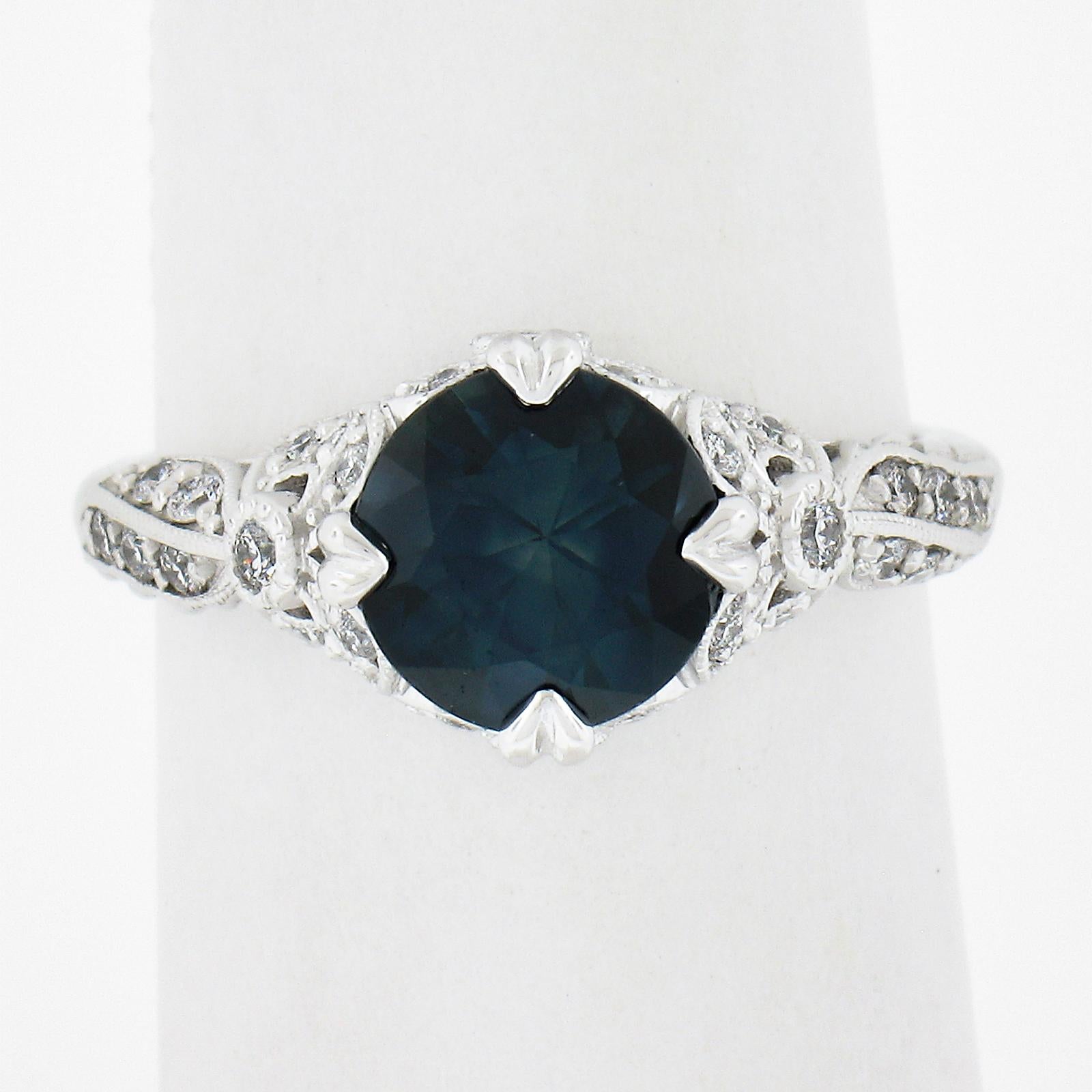 This gorgeous and and well detailed ring features a natural, GIA certified, round cut sapphire weighing approximately 2.25 carat and is perfectly claw-prong set at its center. This gorgeous stone displays a truly mesmerizing slightly greenish blue