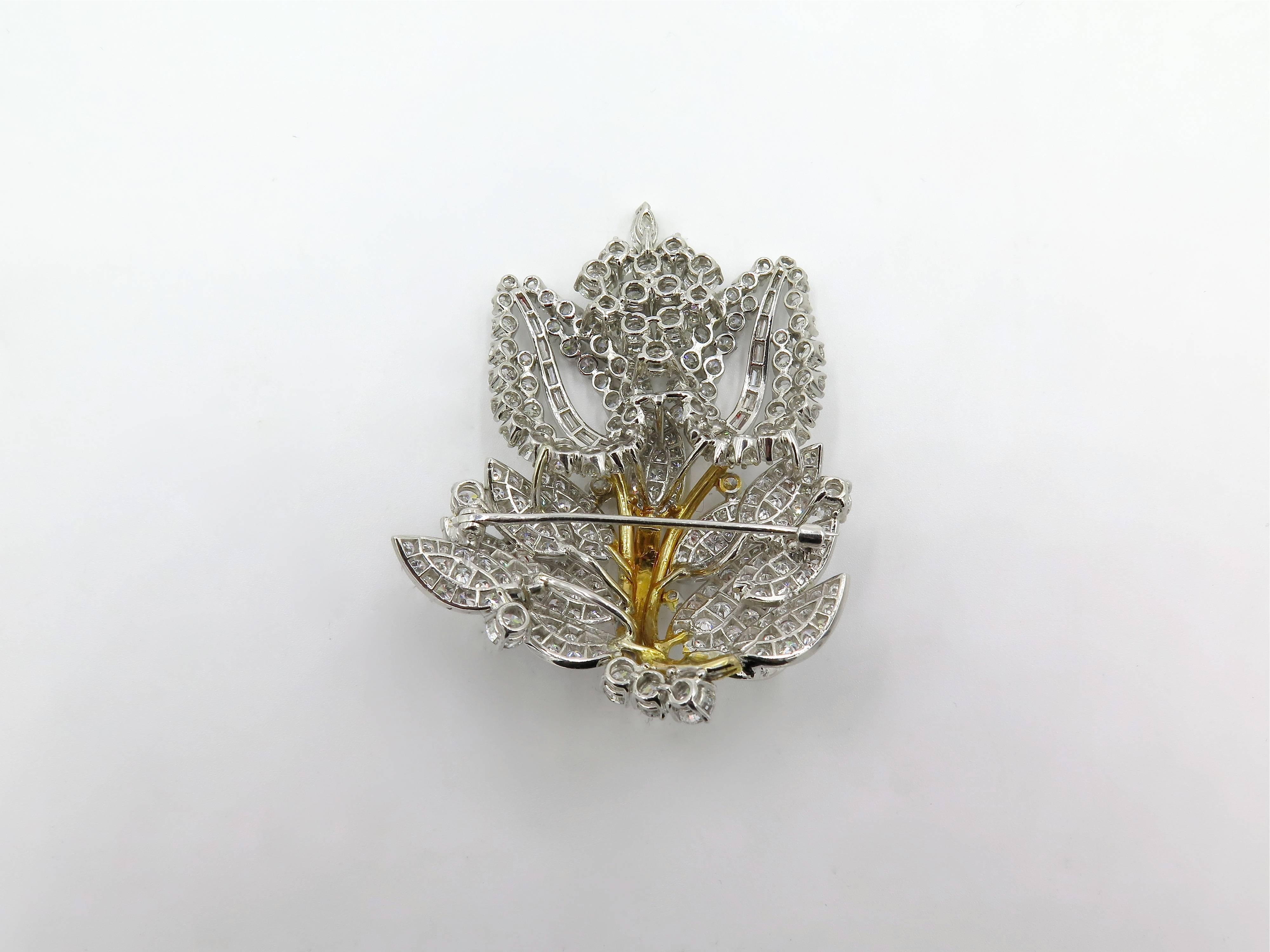 A platinum, 14 karat yellow gold and diamond brooch. Circa 1970. Of openwork foliate spray design, centering a textured gold stem, extending pave set diamond leaves, enhanced by circular, baguette and marquise cut diamonds. Two hundred and seventy